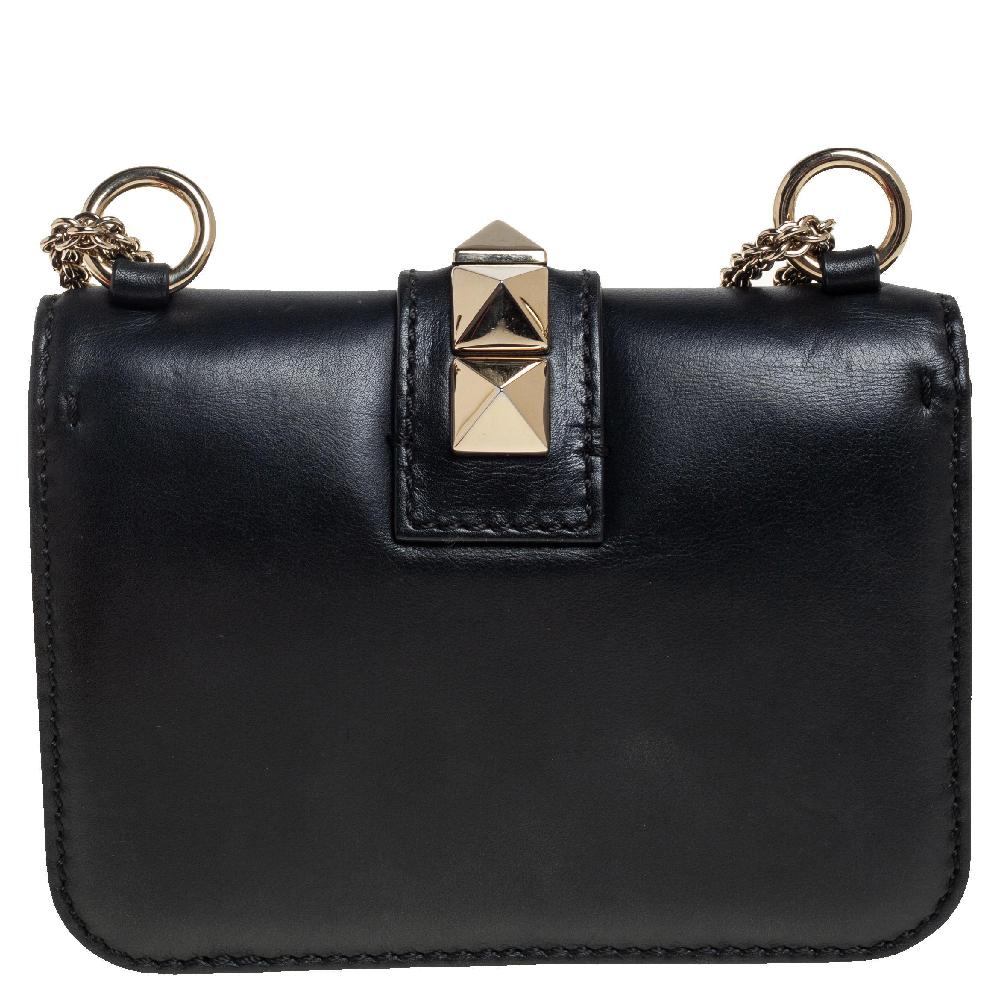 If you are looking for a bag with a blend of modern style and class, this Valentino creation is the answer. Crafted from leather, this black piece comes with a gold-tone chain and a flap with a push-lock to secure the well-sized fabric interior. The