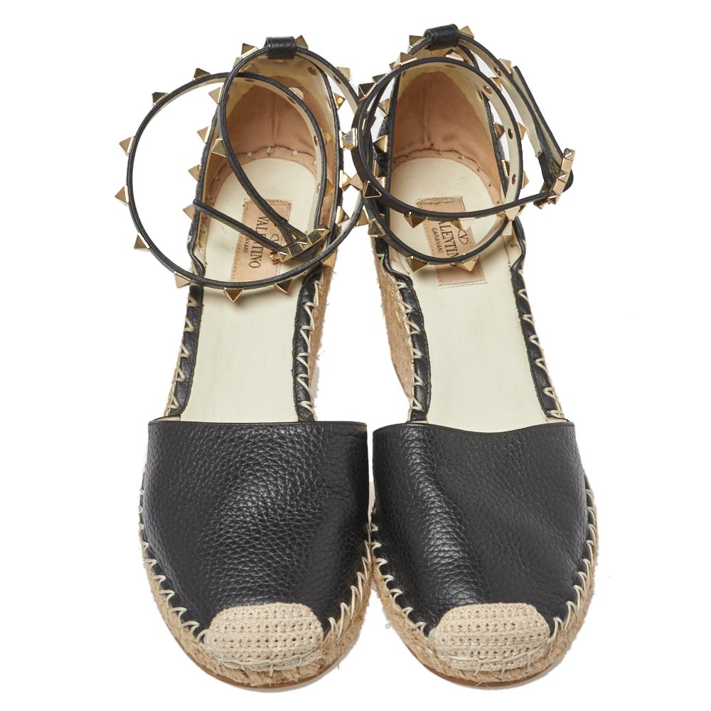 Designed especially for fashion queens like you, these Valentino espadrille sandals are leather-made and breathtakingly gorgeous! They come flaunting ankle straps, jute braided wedge heels, and their signature Rockstud accents adorned on the ankle