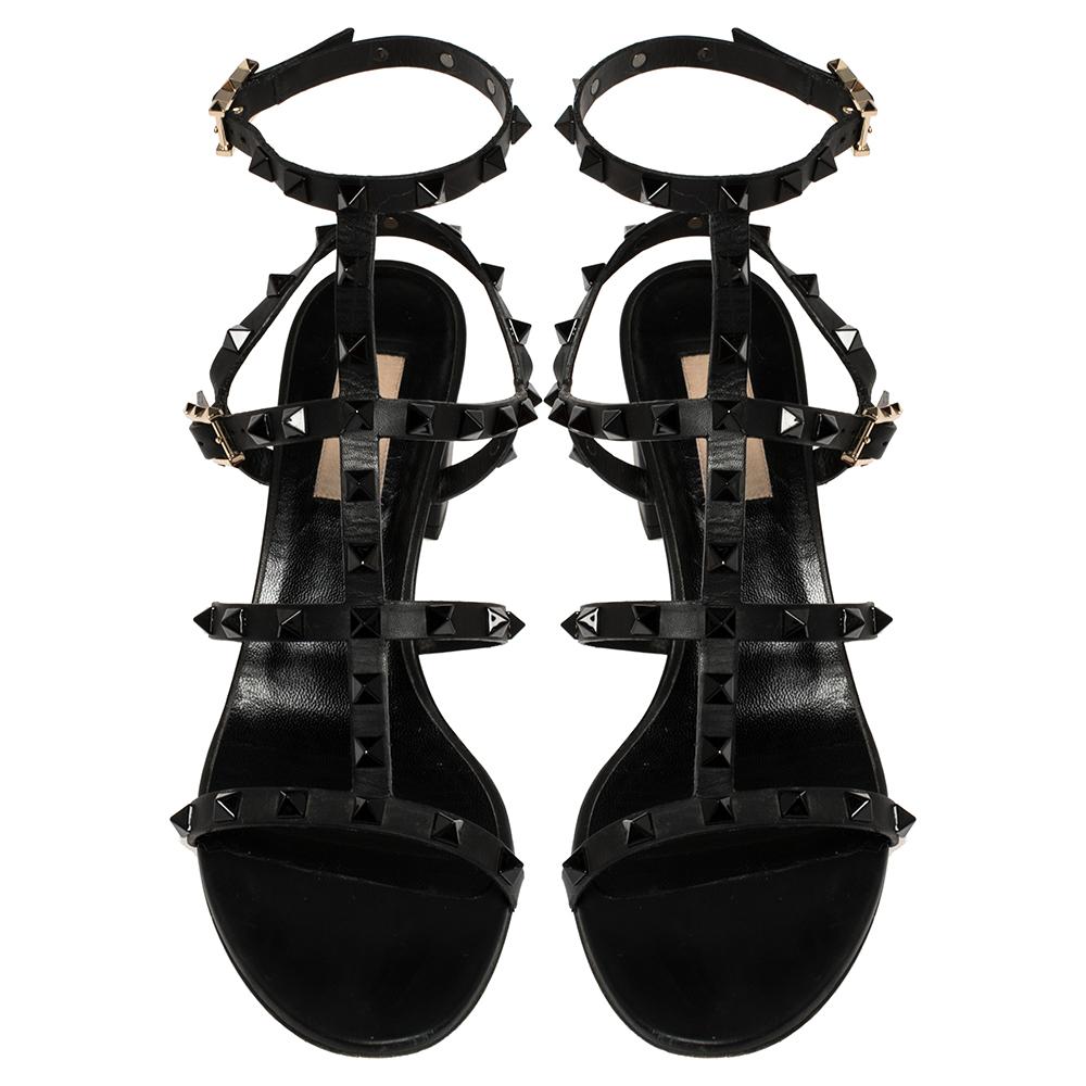 These sandals by Valentino have been designed to introduce your feet to the beauty of Rockstuds and embellishments. Framed in a caged manner using leather straps, the pair in black has buckle closure around the ankle and block heels to grant you an