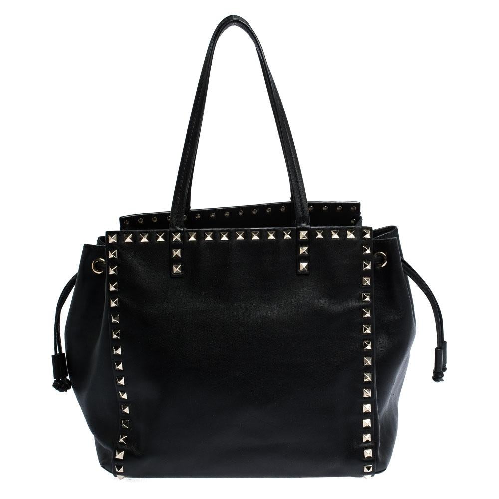 This elegant tote from Valentino is crafted from leather and is perfect for daily use. The bag features double handles, a drawstring and signature stud details. The leather-lined interior is spacious enough to hold all your