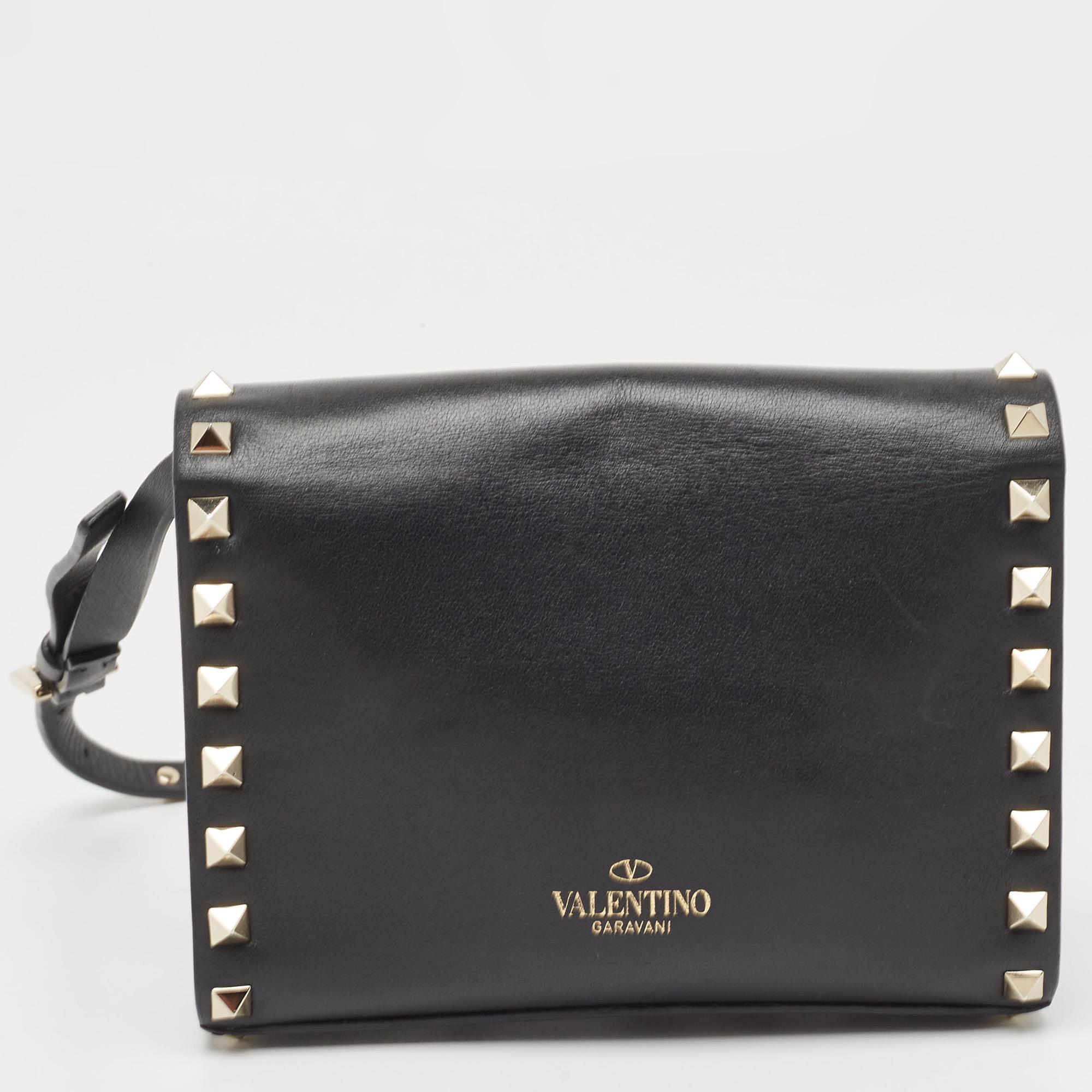 This gorgeous Valentino bag has been crafted in black leather. The exterior features Rockstud detailing in gold-tone on the strap as well as the bag. With a flap closure, the bag opens to a fabric-lined accommodating interior that can hold all your