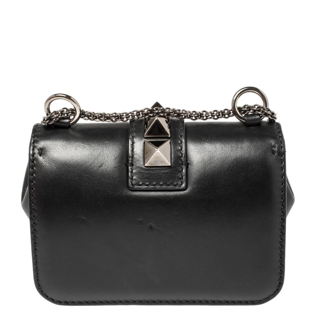 If you are looking for a bag with a blend of modern style and class, this Valentino creation is the answer. Crafted from leather, this black piece comes with a slender chain strap and a flap with a push-lock to secure the well-sized interior. The