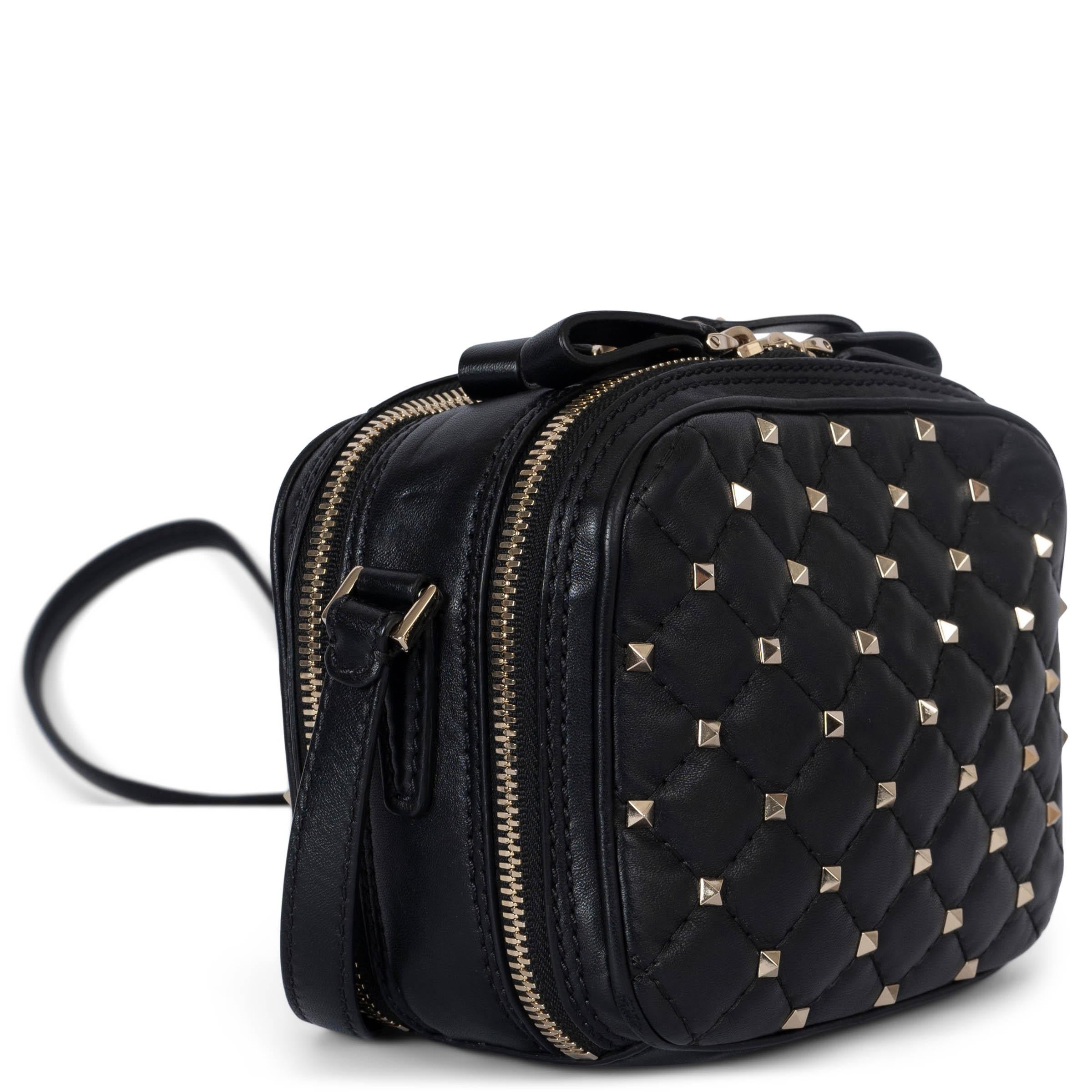 100% authentic Valentino Rockstud Spike Double Zip Camera Bag in black smooth calfskin leather. The design features polished light gold pyramid studs throughout the bag, an adjustable leather strap, and two wrap-around zippers. Opens to a black