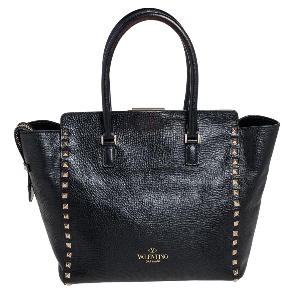 Valentino brings you this super-stylish tote that carries a design that will surely elevate your ensemble. It has a classy black exterior decorated with the signature pyramid Rockstuds. The leather tote is complete with a spacious fabric interior,