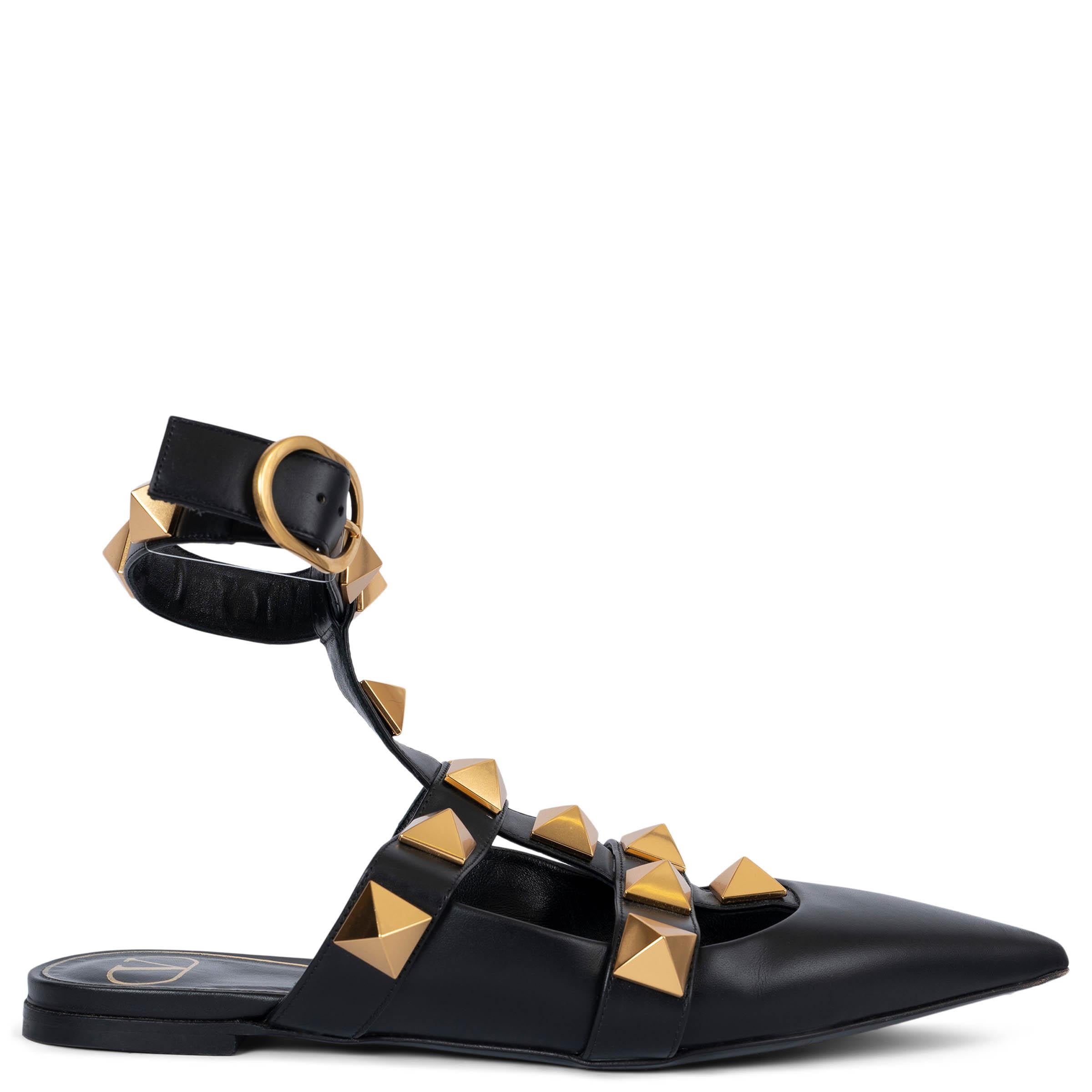 100% authentic Valentino Roman Stud pointed-toe mule flats in black calfskin, studded with a magnified iteration of the house's pyramidal gold-tone hardware and feature buckled ankle strap. Have been worn and are in excellent condition. Come with