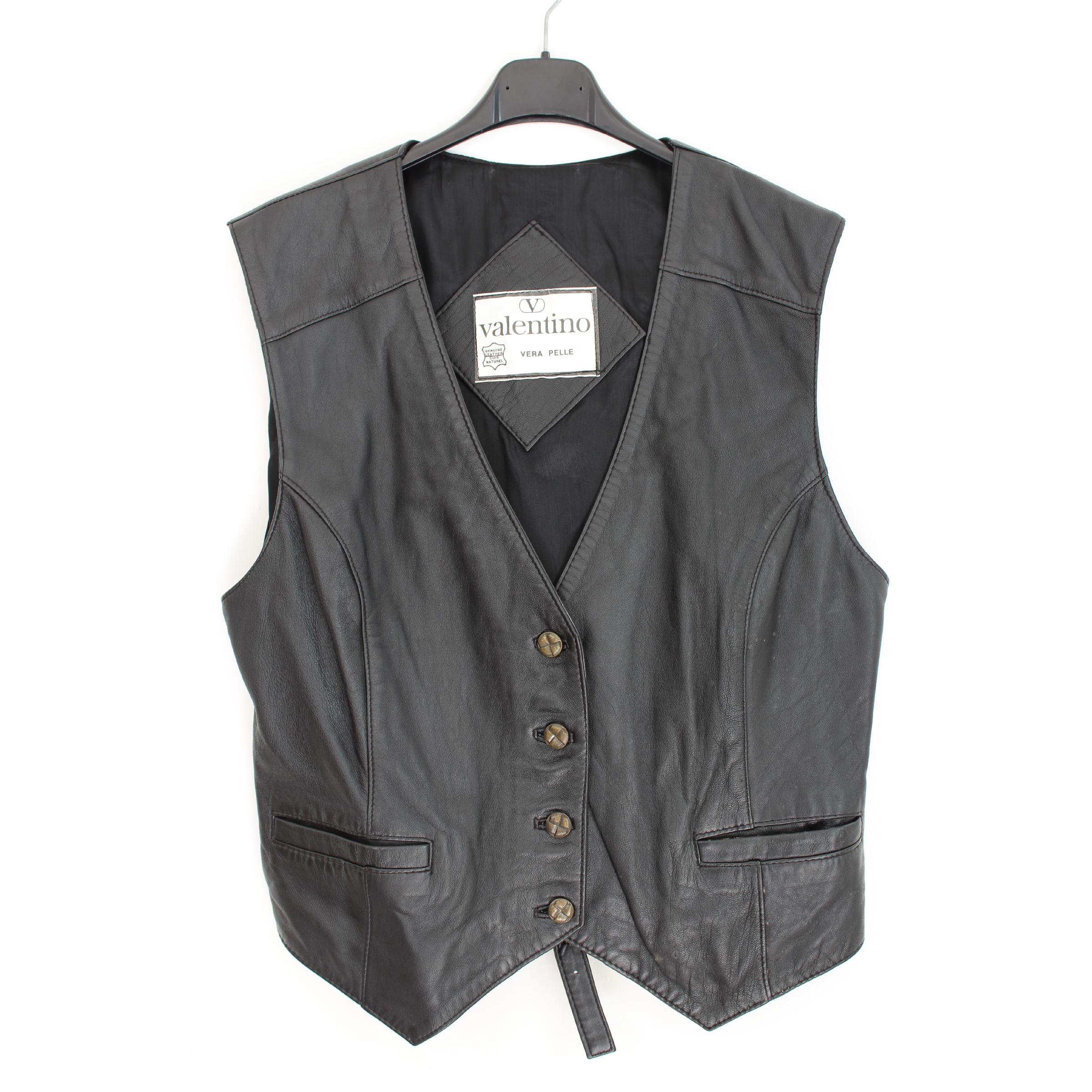 Valentino women's vintage waistcoat, black, 100% leather. Short model biker type, closure with buttons, adjustable strap. 1990s. Made in Italy. Very good vintage conditions.

Size: 42 It 8 Us 10 Uk
Shoulder: 42 cm
Bust / Chest: 50 cm
Length: 59 cm