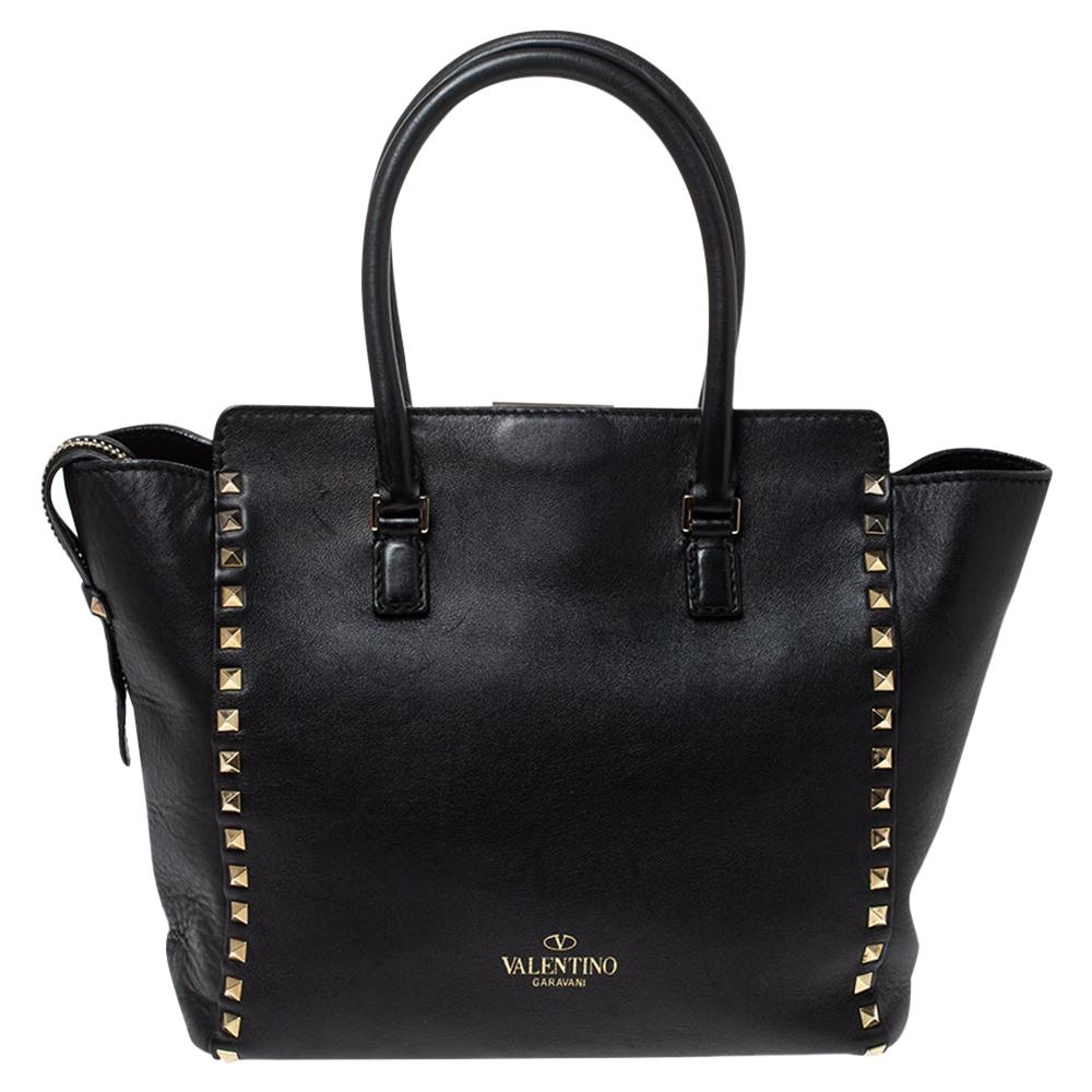 Valentino brings you this super-stylish tote that carries a design that will surely grab the attention of your onlookers. It has a classy black exterior decorated with the signature pyramid Rockstuds. The leather tote is complete with a spacious