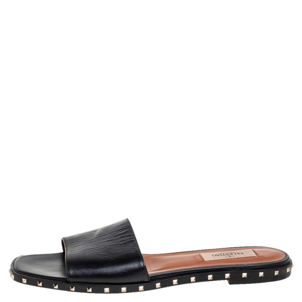 Valentino Slides are perfect for those case-free days without compromising on the style factor. It features a leather body with a wide front strap. It comes with a slim sole detailed with the signature Rockstud on it. Wear yours with everything from