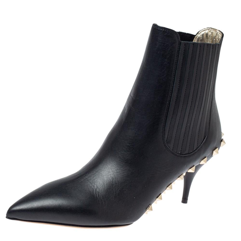 Valentino's creative ways of designing footwear are visible on this pair of booties. Sewn using black leather as a pointed-toe boot, the shoe is elevated on 7 cm heels and decorated with Rockstud motifs along its base.

Includes: Original Dustbag,