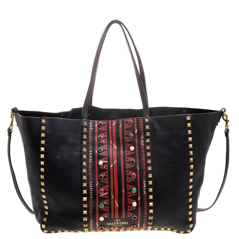 Valentino's signature Rockstud collection is inspired by the exotic African culture. The black tote bag features a tribal print along with the iconic Rockstuds on the exterior, dual handles, and a removable shoulder strap. Made in Italy, the bag is