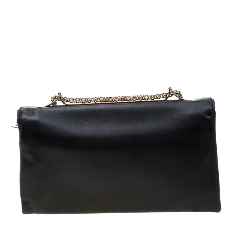 This Va Va Voom clutch bag from Valentino has a pretty captivating design. Crafted from leather, the bag features gorgeous a flap, a canvas interior, and a shoulder chain. It also comes with a hand slot that is decorated with their signature pyramid