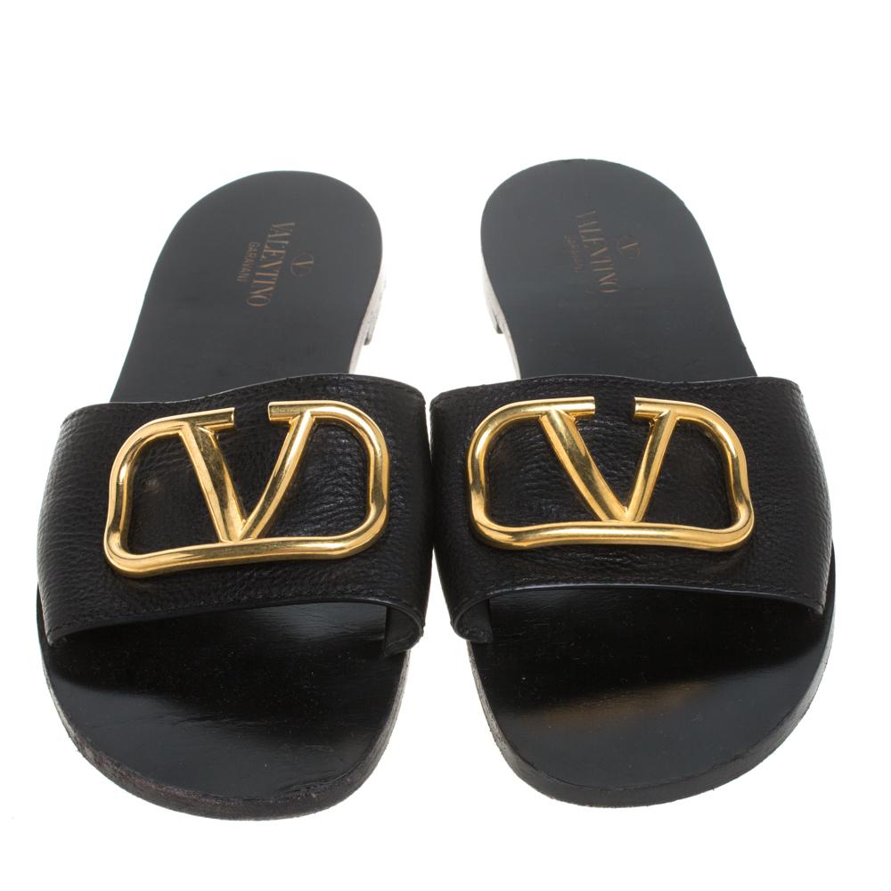 Chic, comfortable, and classy, Valentino's slide flats deserve to be in every fashionista's closet. Crafted from black leather, they feature broad straps accented with the label's iconic Vlogo in gold-tone for an opulent feel. Wear them with