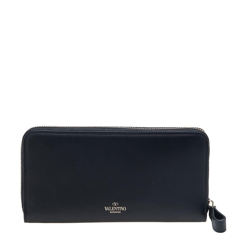 This wallet from the House of Valentino is great for everyday use. It is created using black leather, with a contrasting VLTN print on the front. It has a zip-around feature that opens to a leather-fabric interior. This Valentino wallet will be your