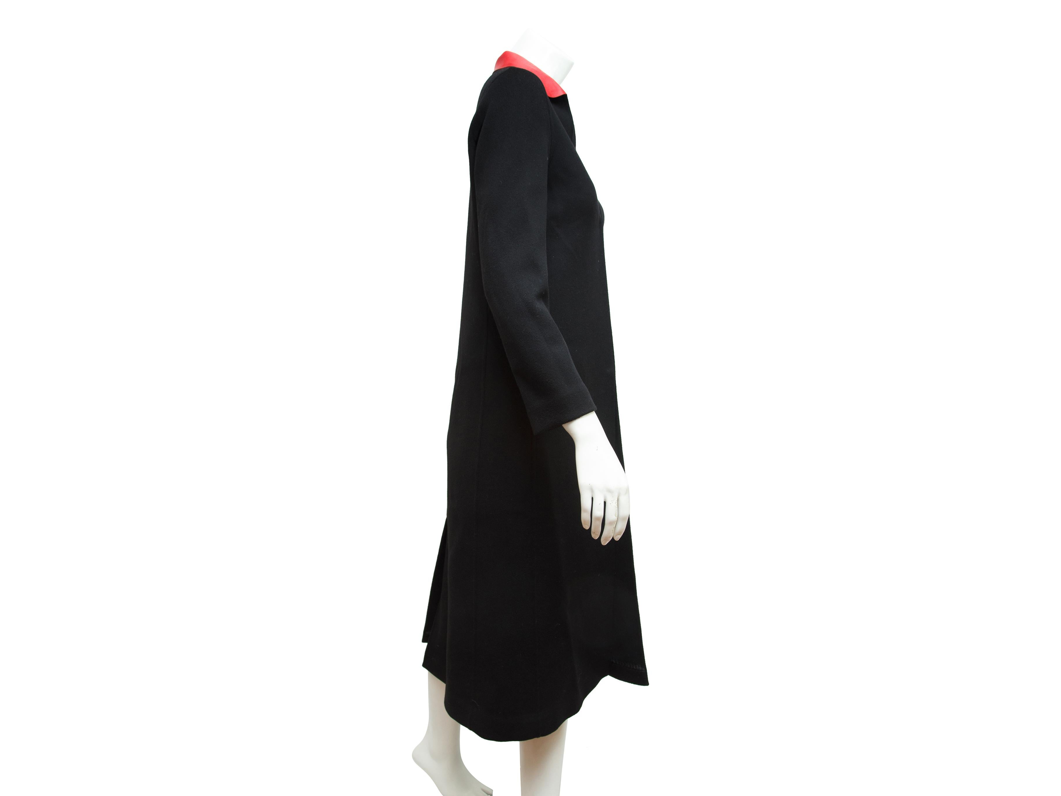 Product details:  Black long wool coat by Valentino.  Red spread leather collar.  Long sleeves.  Concealed front closure.  Center back hem vent.  Label size IT 40.  38