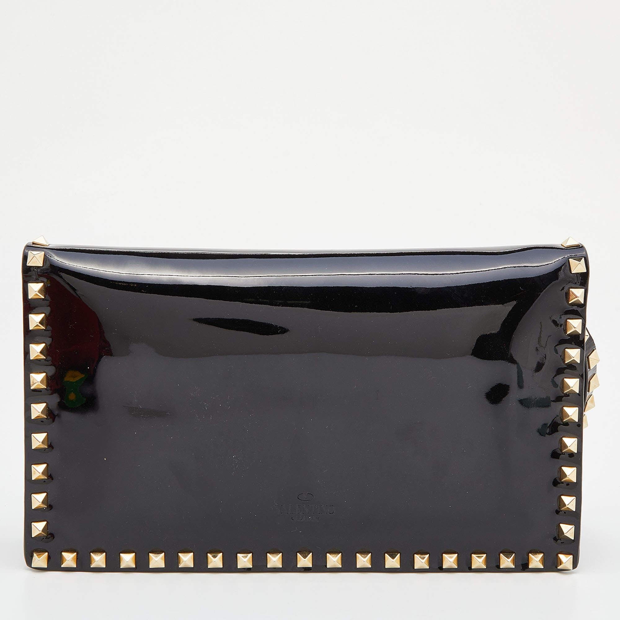 This Valentino clutch is a statement piece to add to your closet. Designed to deliver effortless style, it is crafted in Italy from quality patent leather. It comes in a lovely shade of black and is accented with the brand's signature Rockstuds. It