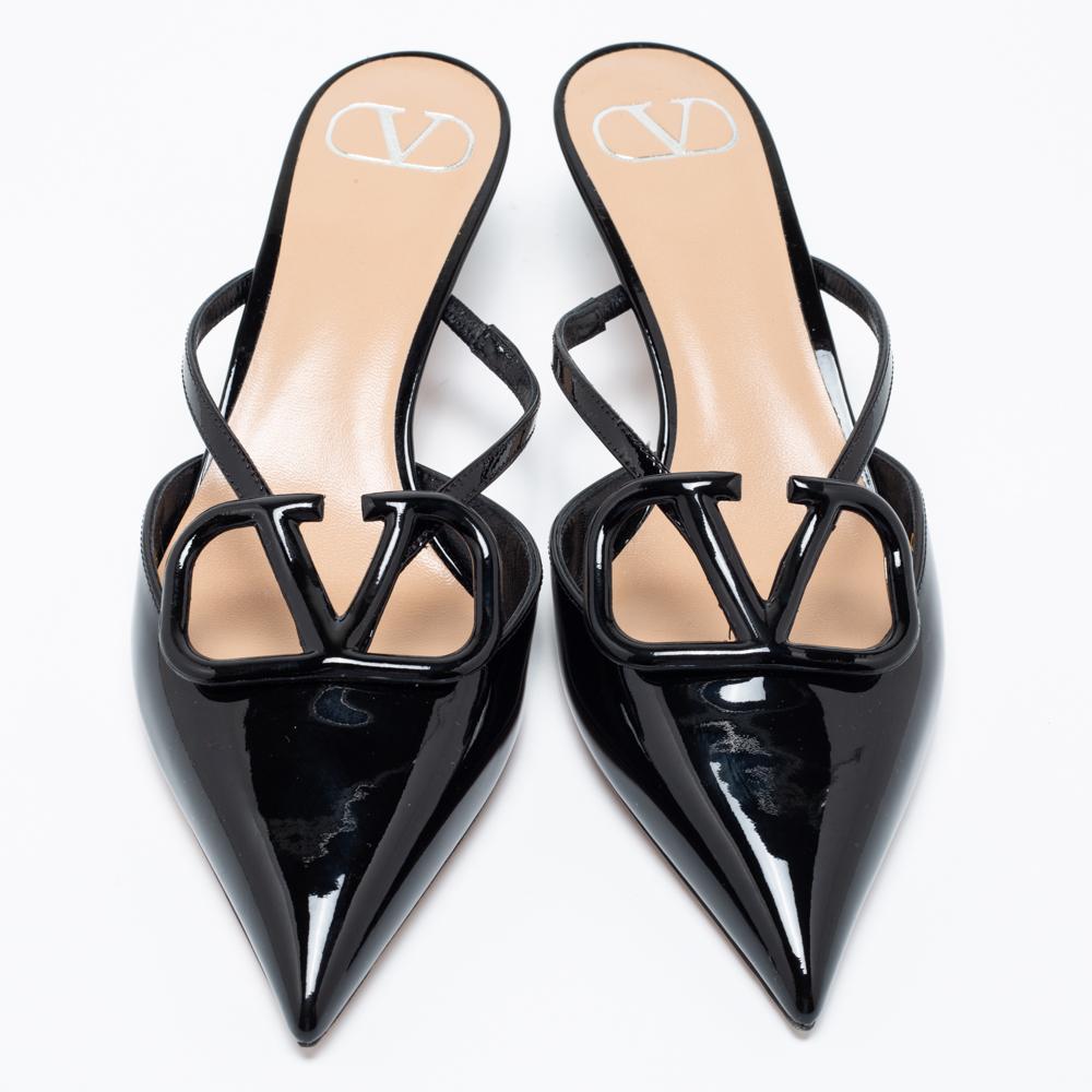 Add a chic touch to your outfit with these beautiful mules from the House of Valentino. They are created using black patent leather and exhibit pointed toes, a VLogo accent on the upper, and 5 cm heels. Elevate the look of any attire by wearing
