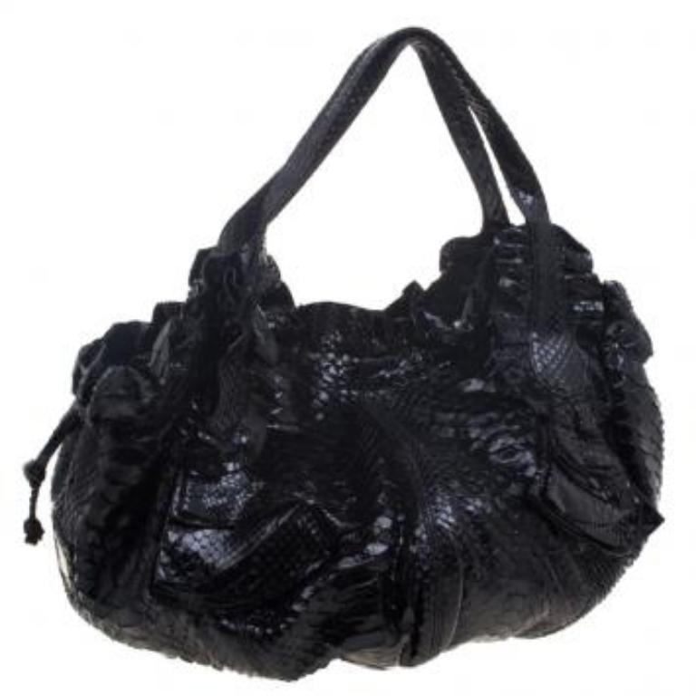 Crafted from exotic python skin, the hobo is perfect to flaunt at the parties. The Italian made beauty with inner satin lining has a spacious interior that houses a zip pocket. Accentuated with gold tone hardware, the bag features a magnetic snap