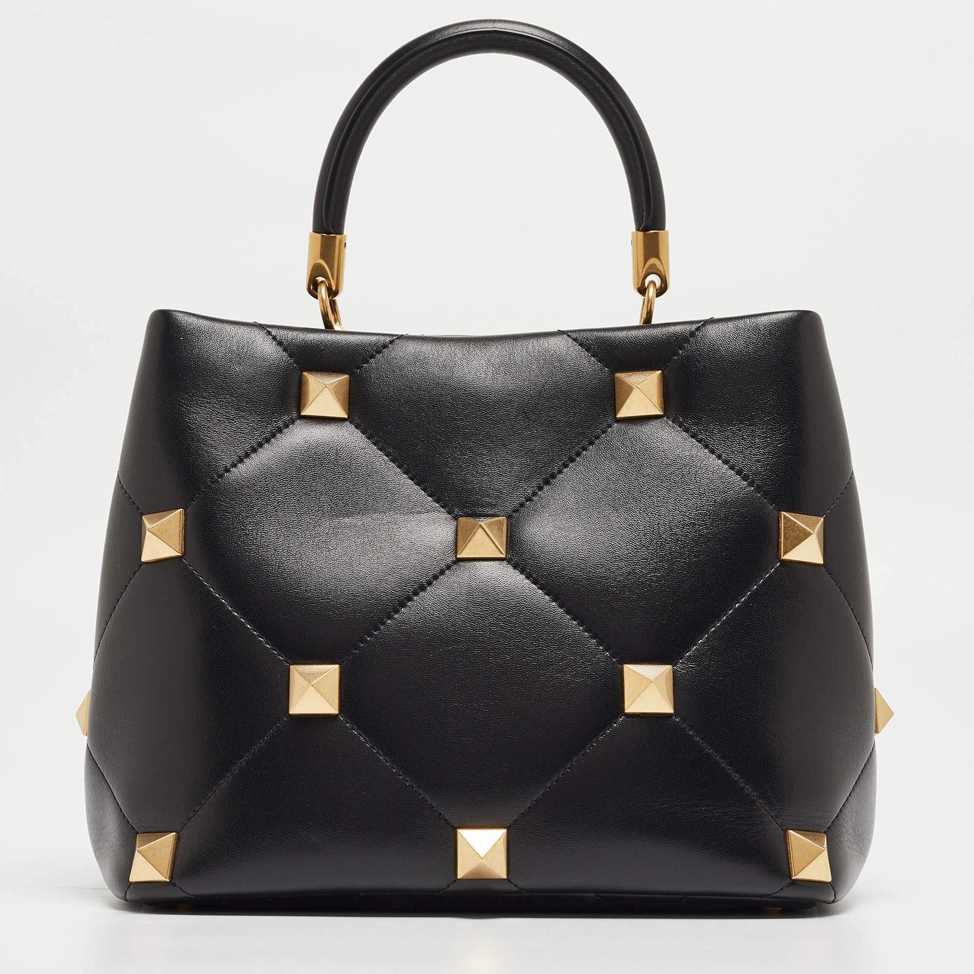 Imbued with timeless allure, the Valentino Roman Stud Top Handle Bag epitomizes refinement. Crafted from supple leather, its quilted design exudes sophistication. Adorned with gleaming Roman studs, it blends classic elegance with modern edge, making