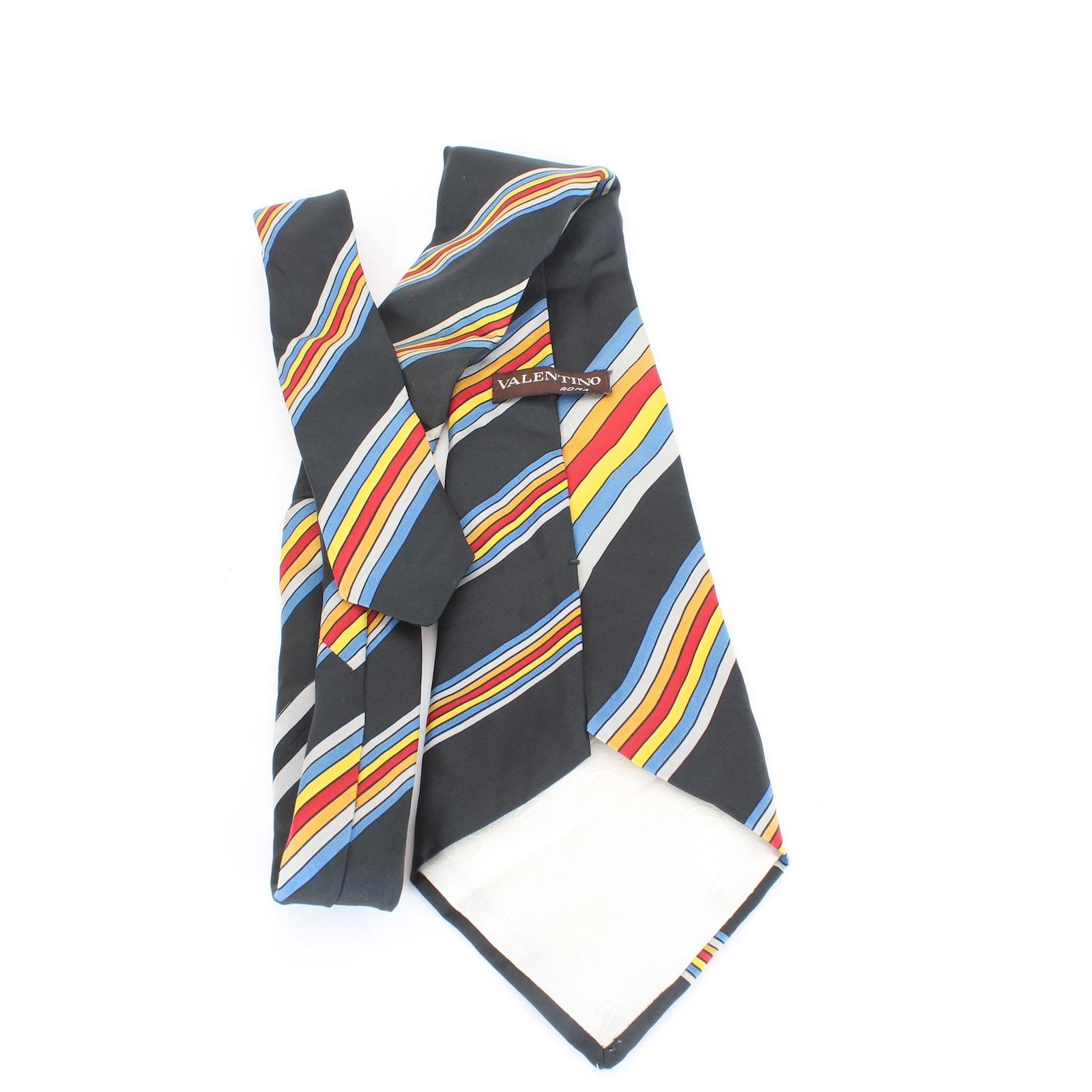 Valentino vintage 90s tie. Black background color with red, blue and yellow striped pattern, 100% silk. Made in italy.

Length: 137 cm
Width: 13 cm