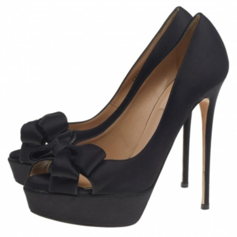 Add a luxe finish to your outfit with these Valentino platform pumps. They are crafted from black satin and designed with bows, peep toes, platforms, and 14 cm heels.