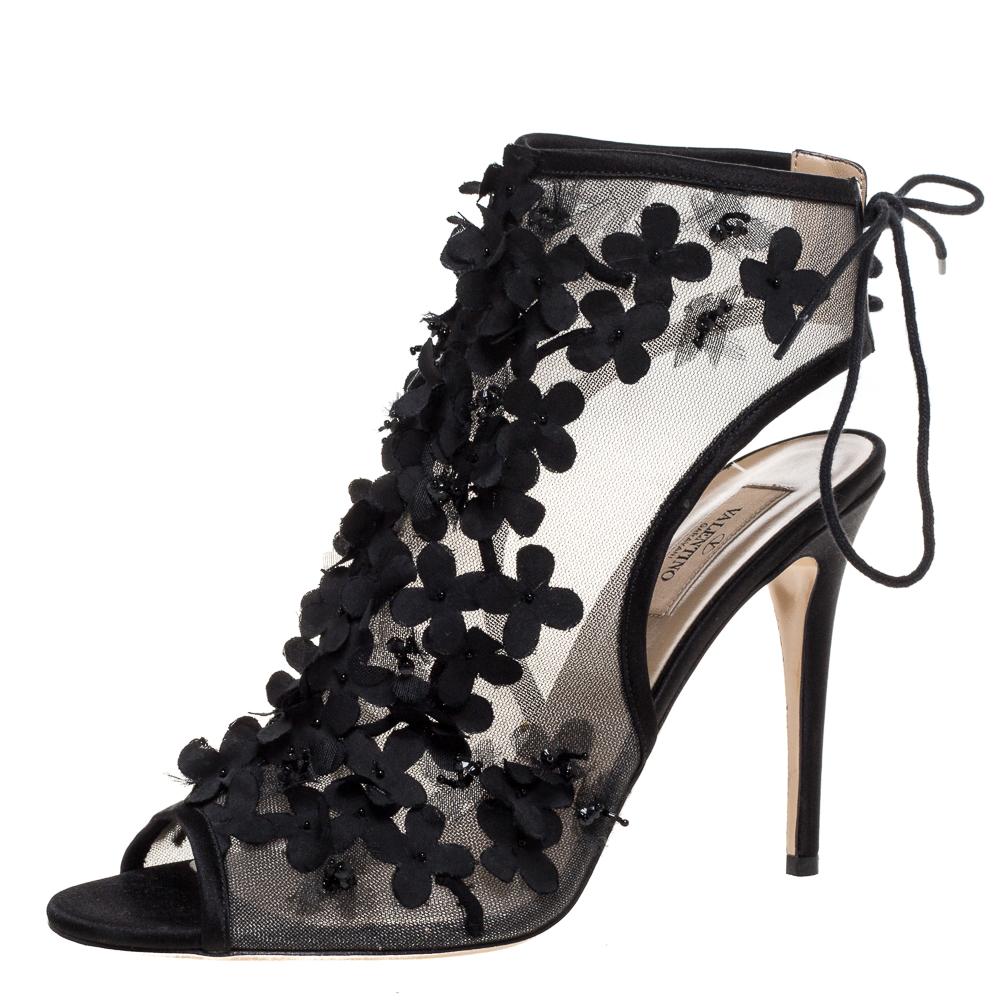 Reich an Details und voller Eleganz sind diese Ankle Booties von Valentino einzigartig! Diese schwarzen Booties aus Mesh und Satinbesätzen haben eine offene Zehensilhouette. Sie sind mit Blumen auf dem Riemen des Vorderblattes verziert und sichern