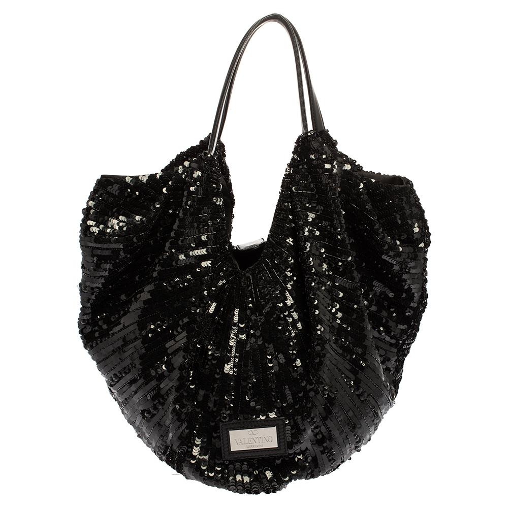 Valentino's impeccable craftsmanship and feminine appeal are perfectly exemplified in this hobo bag loved by celebrities. Crafted from leather and covered with black sequins, it features an exaggerated tonal bow at the front. The bag is held by dual