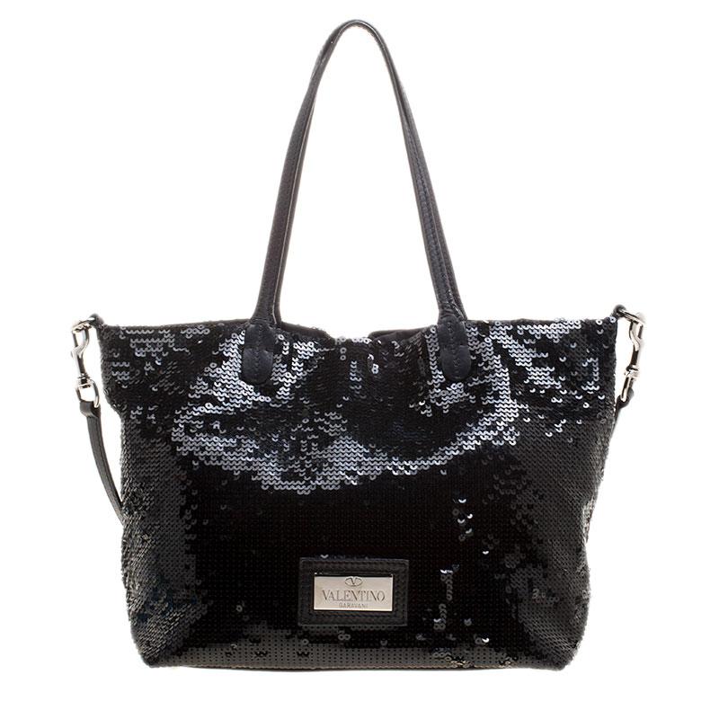 Dive deep into this most luxurious tote from Valentino with voluminous space made from soft fabric. It is finely stitched with glittery sequins forming a concentric circle in the front that can be carried to a party making you look chic. It is