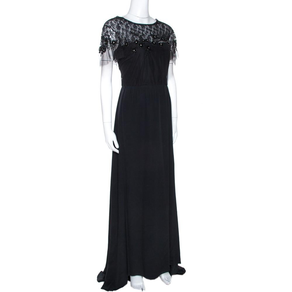 This Valentino maxi dress is perfect for special occasions. Crafted from quality silk, it comes in black. It is designed to deliver sophistication and effortless elegance. It is styled with a round neck, lace trims that extend to form sheer sleeves