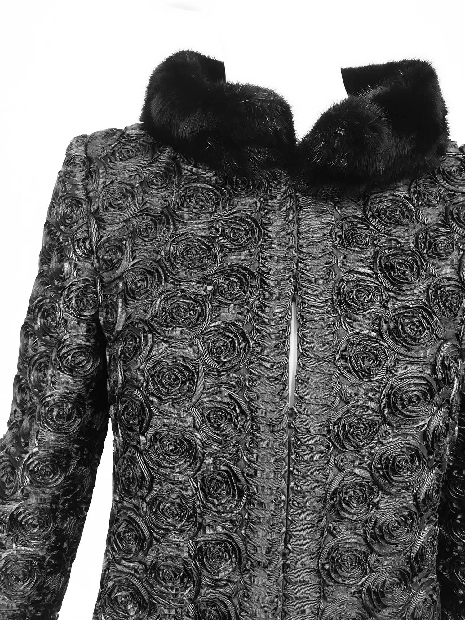 Valentino black silk faille applique coat with mink collar. The fabric is sewn with three dimensional ribbons of silk faille in the shape of roses, the facings are interwoven ribbons of silk faille that form a geometric pattern. Princess seamed coat
