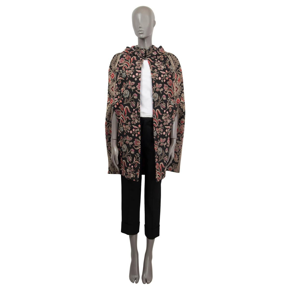 100% authentic Valentino hooded cape in black, pink, taupe, red and light blue floral jacquard cotton (74%), polyester (20%) and viscose (6%). Featrures has a stand-up color and a box pleat at the back. Closes with a single hook on the neck. Has