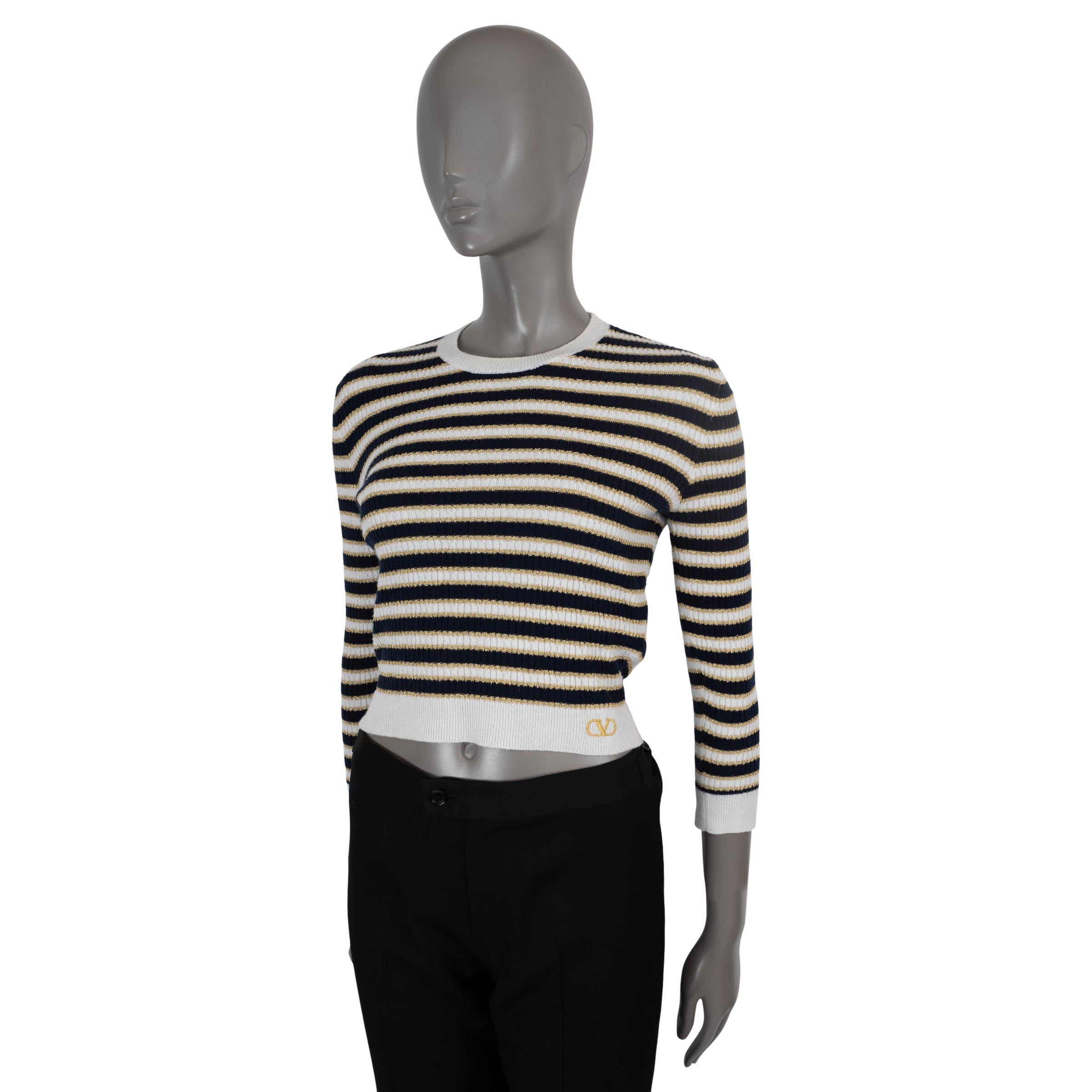 Pull cropped 100% authentique Valentino en laine (38%), cachemire (31%), viscose (25%) et fibre métallisée (6%) rayés de lurex blanc, noir et or. Col ras du cou, bordures en tricot côtelé et VLogo brodé à la taille. A été porté et est en excellent