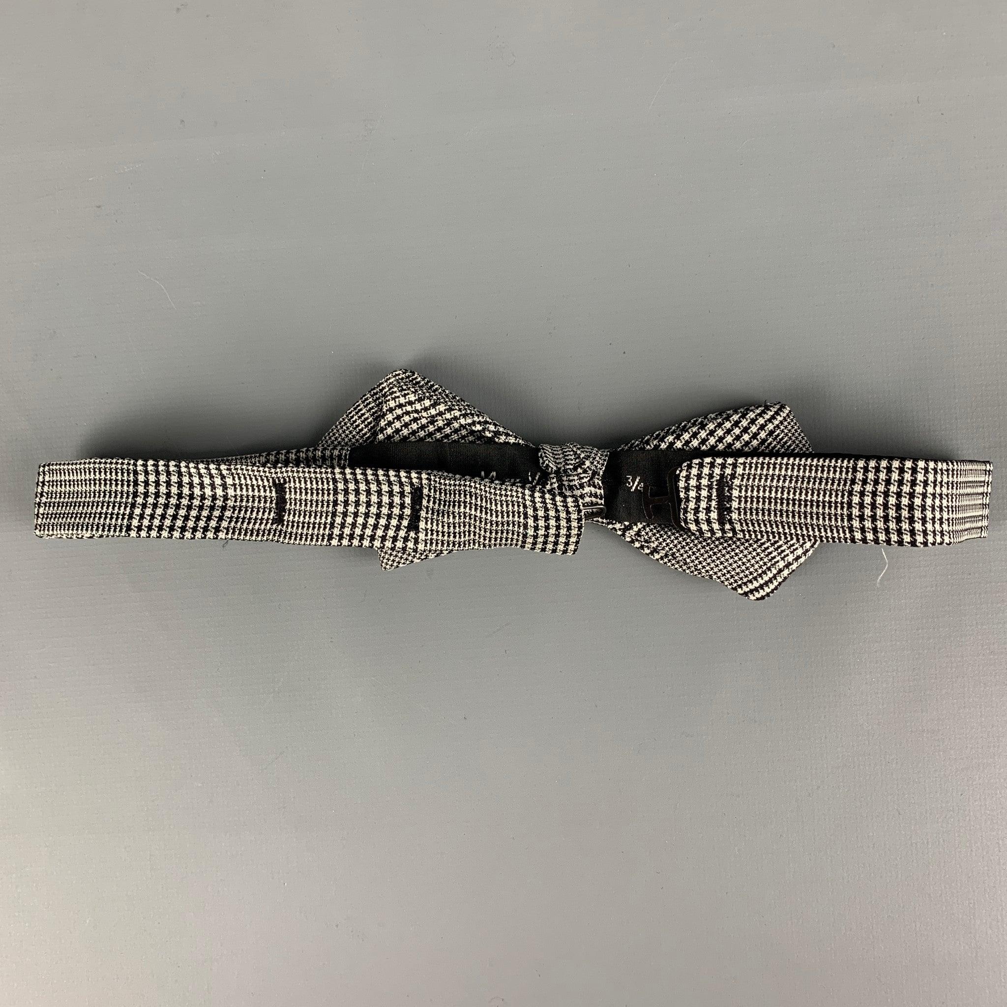 VALENTINO bow tie comes in a black & white houndstooth silk featuring a adjustable fit.
 Very Good Pre-Owned Condition.
 Height: 2.5 inches 
  
  
  
 Sui Generis Reference: 118694
 Category: Bow Tie
 More Details
  
 Brand: VALENTINO
 Color: Black
