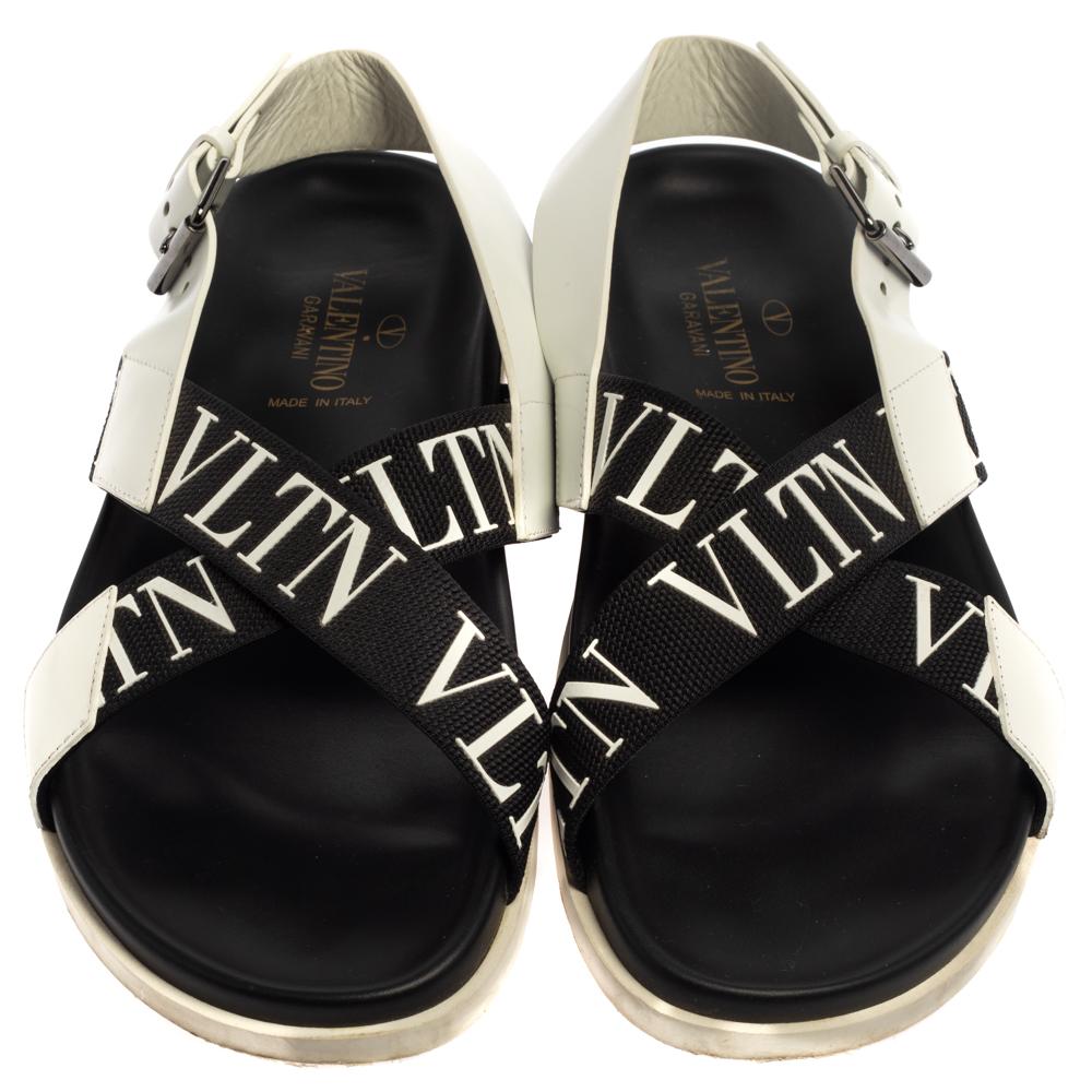 Valentino lends a branded finish to a simple design with these flats. The sandals feature VLTN-detailed straps laid in a criss-cross manner on the vamps, held by buckled leather backstraps. Durable rubber soles complete the pair.

Includes: Original