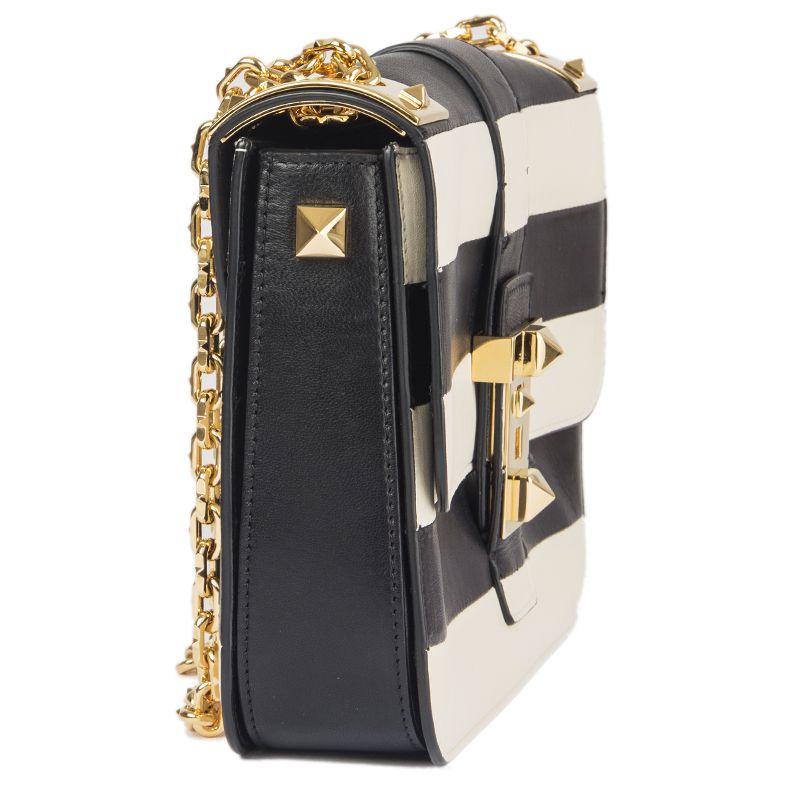 Valentino 'B-Rockstud' shoulder in black and off-white striped leather. Closes with a lock on the front. Divided into three compartements. Lined in black leather with a zipper pocket in the center. Has been carried and is in excellent condition.
