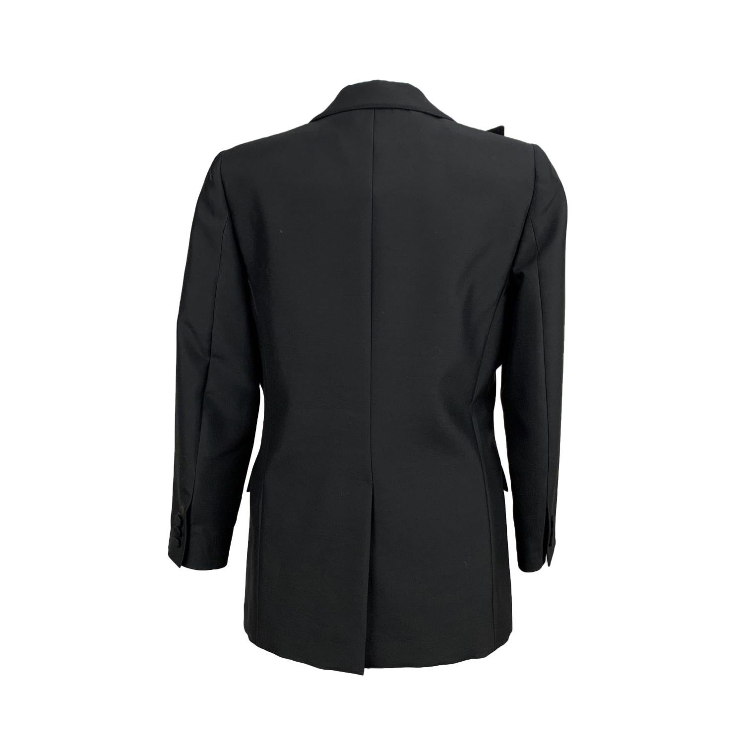 VALENTINO blazer in black wool blend fabric. It features ruffled lapel. Long Sleeves with buttoned cuffs. 2 flap pockets. Lined. Composition: 72% Fleece Wool, 28% Silk. Size: 6 (The size shown for this item is the size indicated by the designer on
