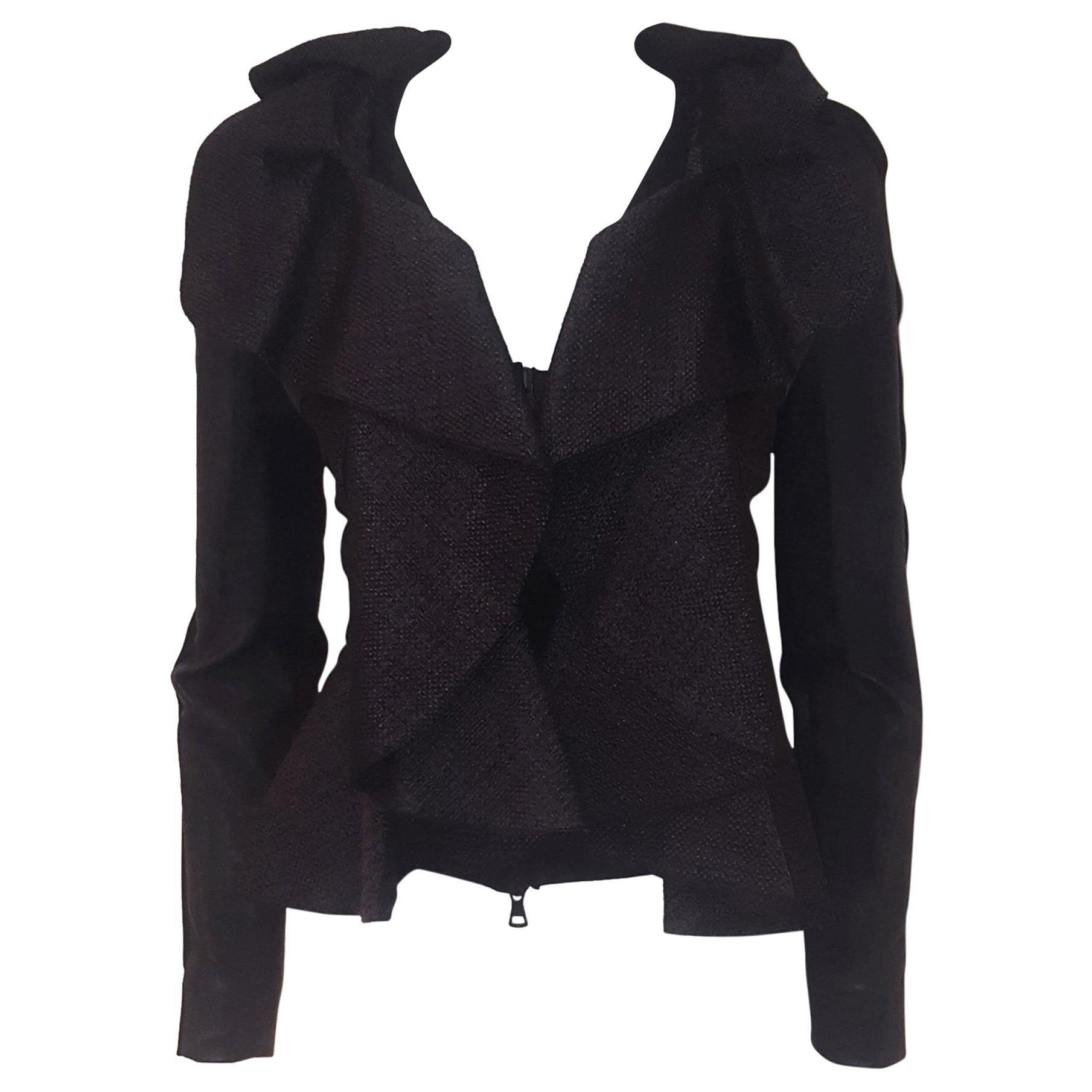 Valentino black wool and silk jacket features a tailored ruffle collar flowing down the front and around the hem of the jacket.  This expertly crafted jacket has a stark zipper and ruffles that have a textured woven look.  The long sleeves are soft