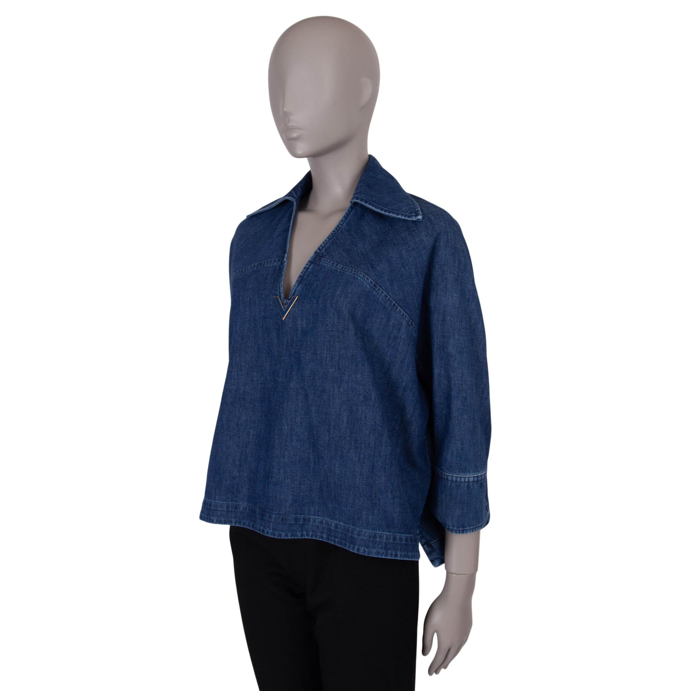 This 100% authentic Valentino shirt in medium blue chambray denim cotton (100%) embodies effortless sophistication. Featuring a relaxed silhouette, 3/4 sleeves, a spread collar, and a deep V-neck adorned with an enameled VLogo, it strikes the