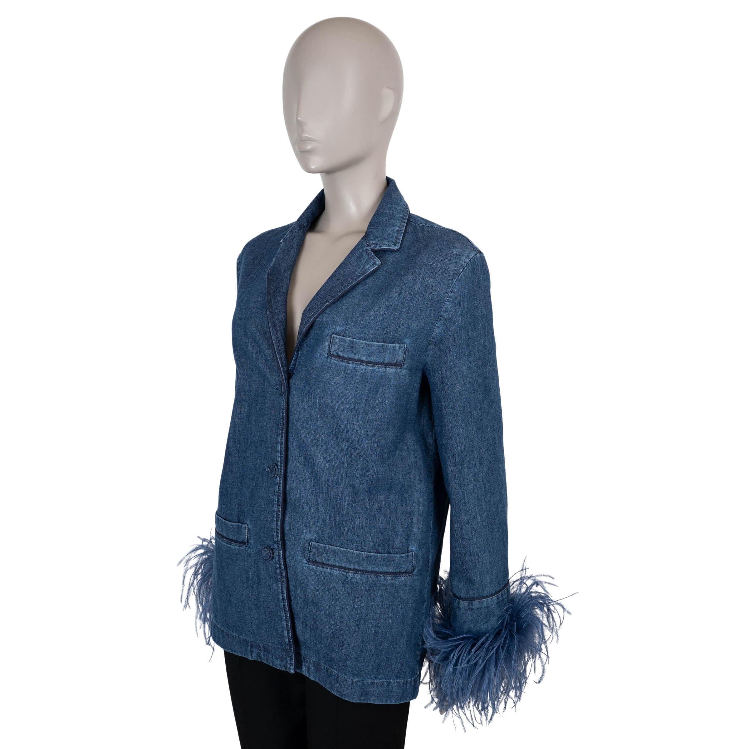 Questa camicia di Valentino, autentica al 100%, è realizzata in denim chambray di cotone blu medio. Disegnata con una silhouette rilassata, presenta maniche a 3/4 rifinite con piume tonali, rever a specchio e tre tasche funzionali: una sul petto e