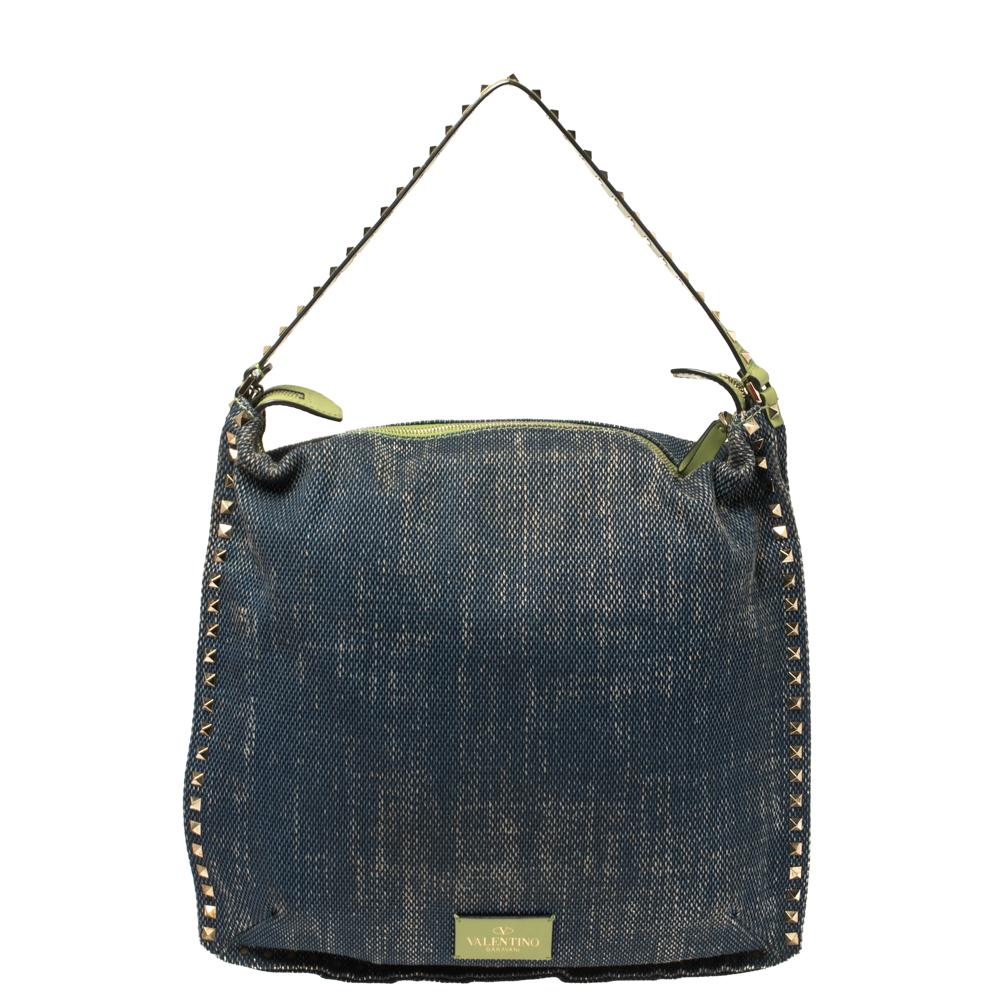 This easy-to-carry Valentino Rockstud messenger bag can be paraded from workday to the weekend. It has a smart and practical design. The bag is crafted using denim, detailed with signature studs, and lined with canvas. It is held by a green top