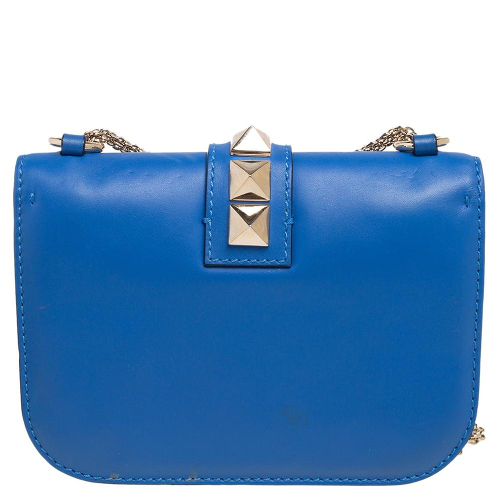 If you are looking for a bag that offers a blend of modern style and elegance, this Valentino creation is the answer. This mini Glam Lock bag from Valentino is super chic and classy! It is made from blue leather on the exterior, with a studded lock