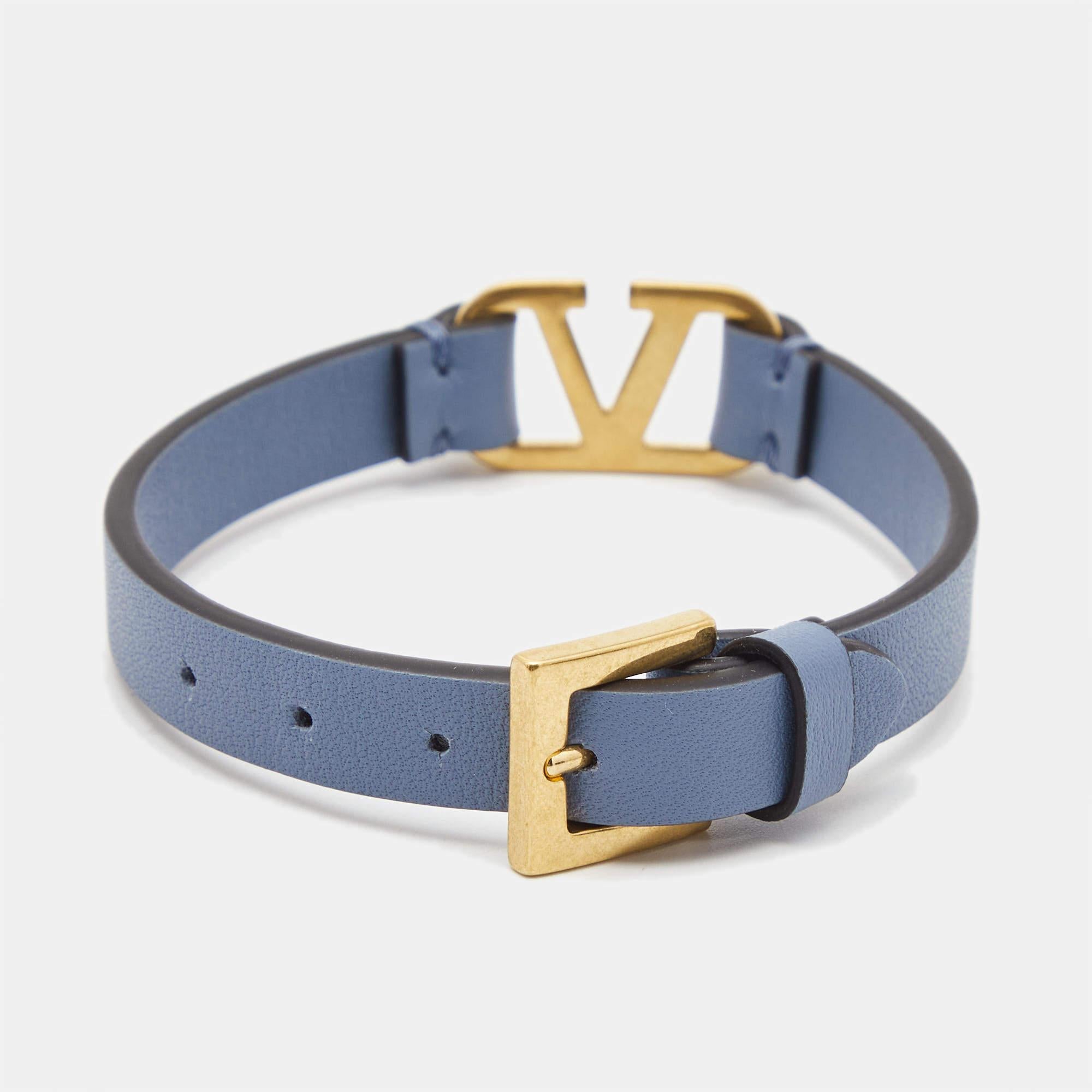 Valentino's loved VLogo motif is chosen as the highlight of this simple bracelet. The charm in gold-tone metal is held by a blue leather bracelet that can be secured to your wrist with the buckle clasp.

Includes: Original Dustbag, Original Box,