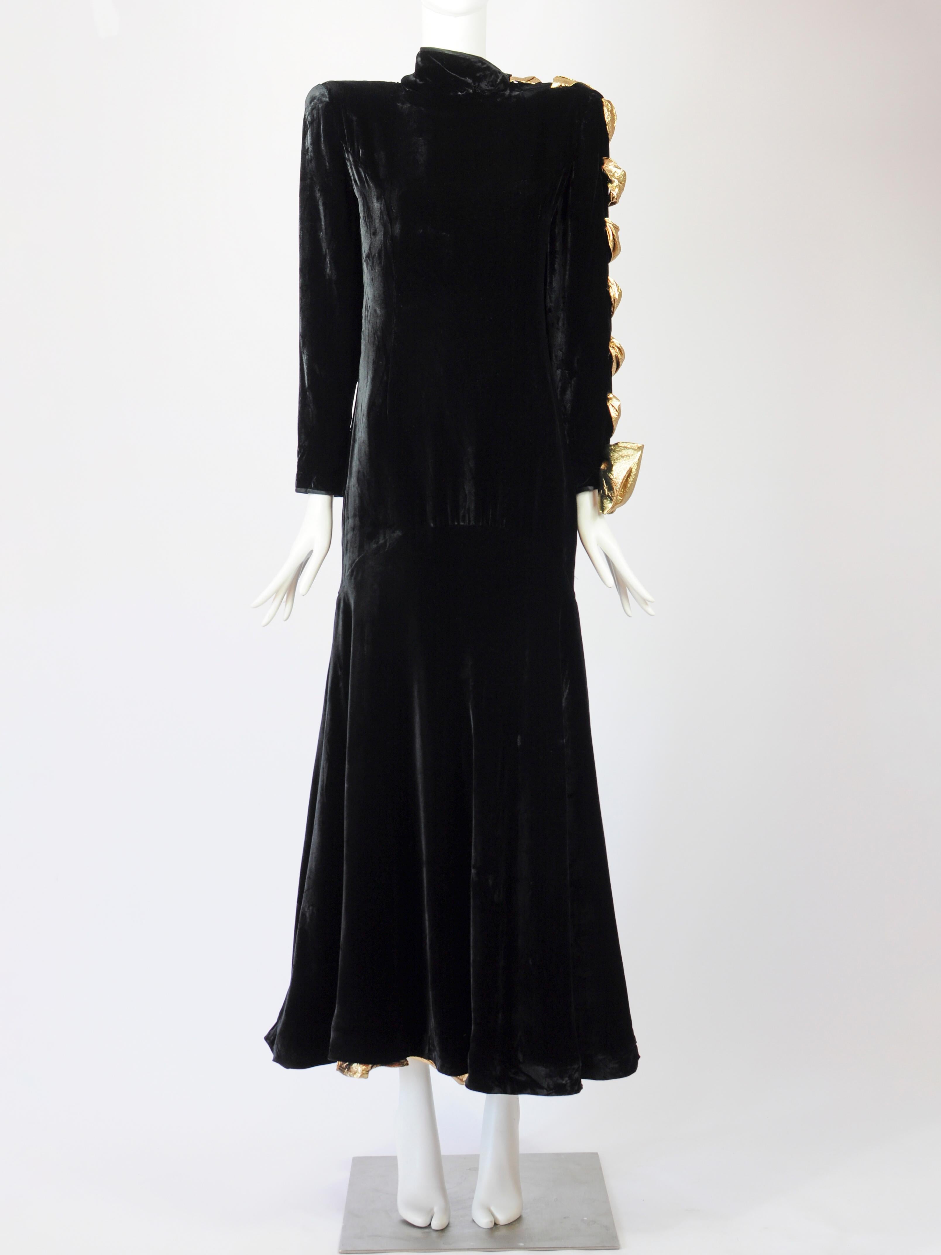 Vintage Valentino Boutique F/W 1987 1988 collection velvet gown with long sleeves and a gold lame bow on one sleeve. The maxi dress has an asymetric collar, padded shoulders, a dropped waist and a generous skirt. The skirt has a gold layer