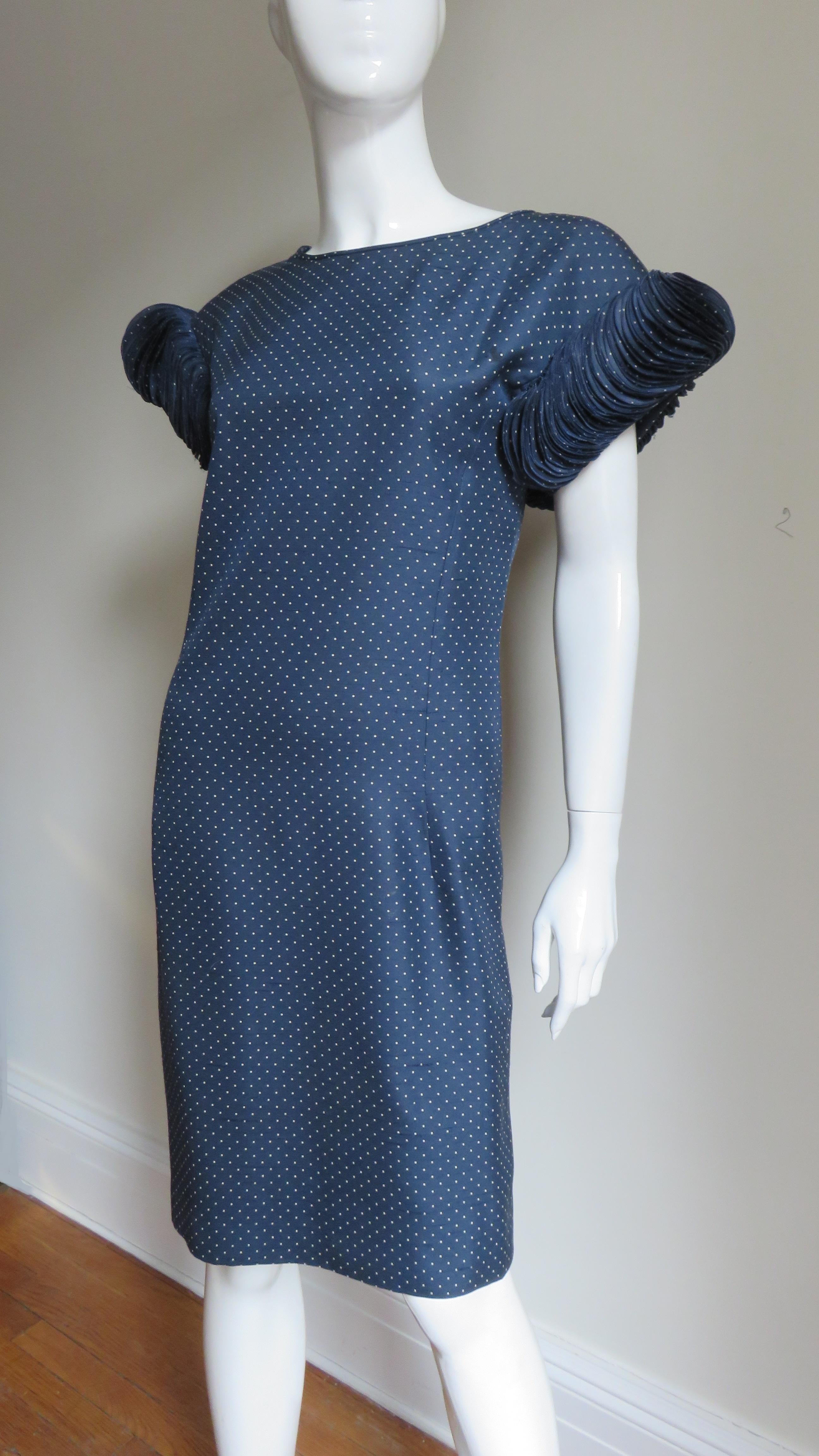 A fabulous navy silk dress with tiny white dots dress from Valentino.  The cap sleeves are incredible, the ends of them encircled with several 100 finished circles adding dimension and movement.  Such an immense amount of work.  The dress skims the
