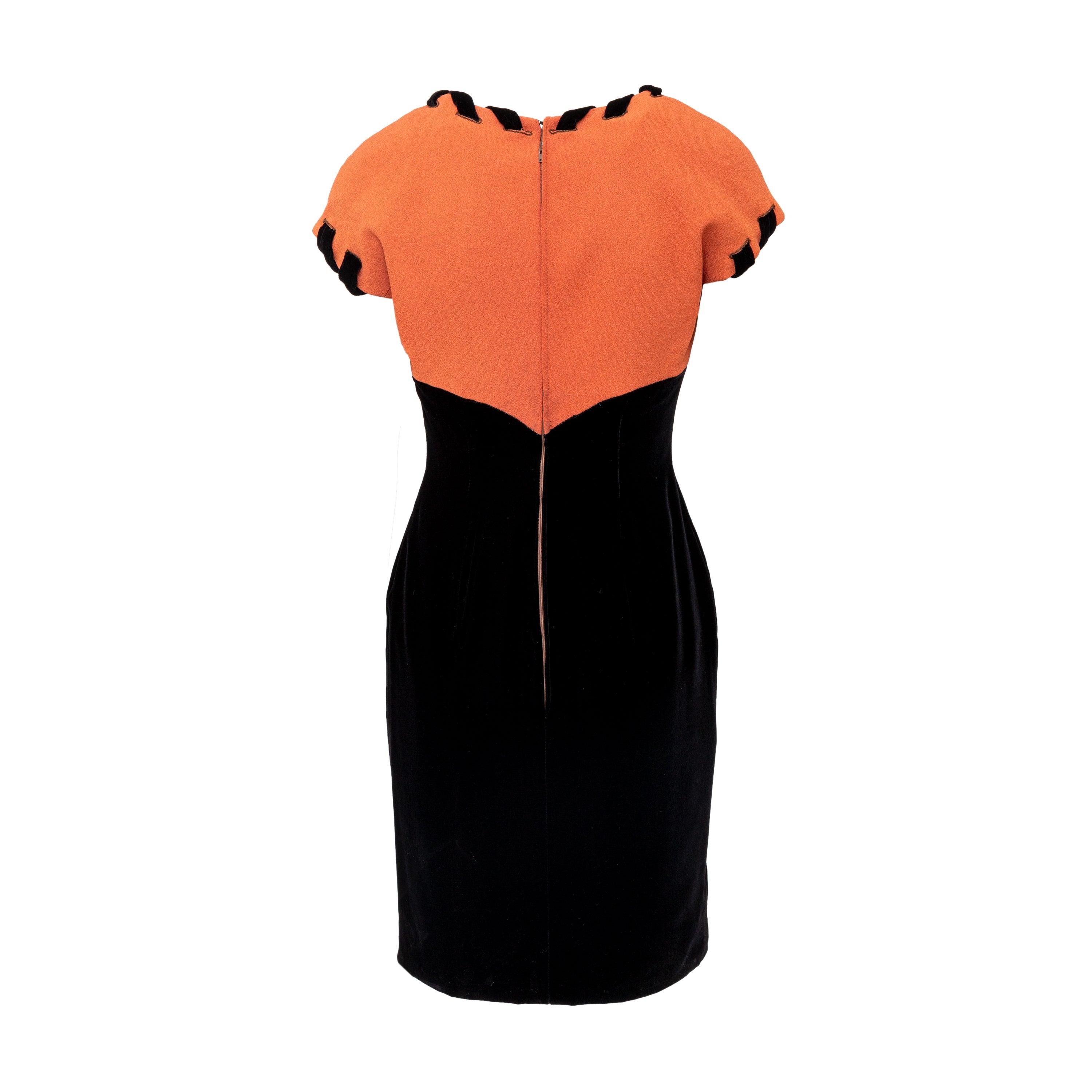 From Autumn Winter 1991 collection, this Valentino Boutique Velvet Dress features a fitted silhouette and a velvet lower part with a contrasting orange upper. The V-neck and short sleeves add a touch of elegance, while the hidden zip on the back