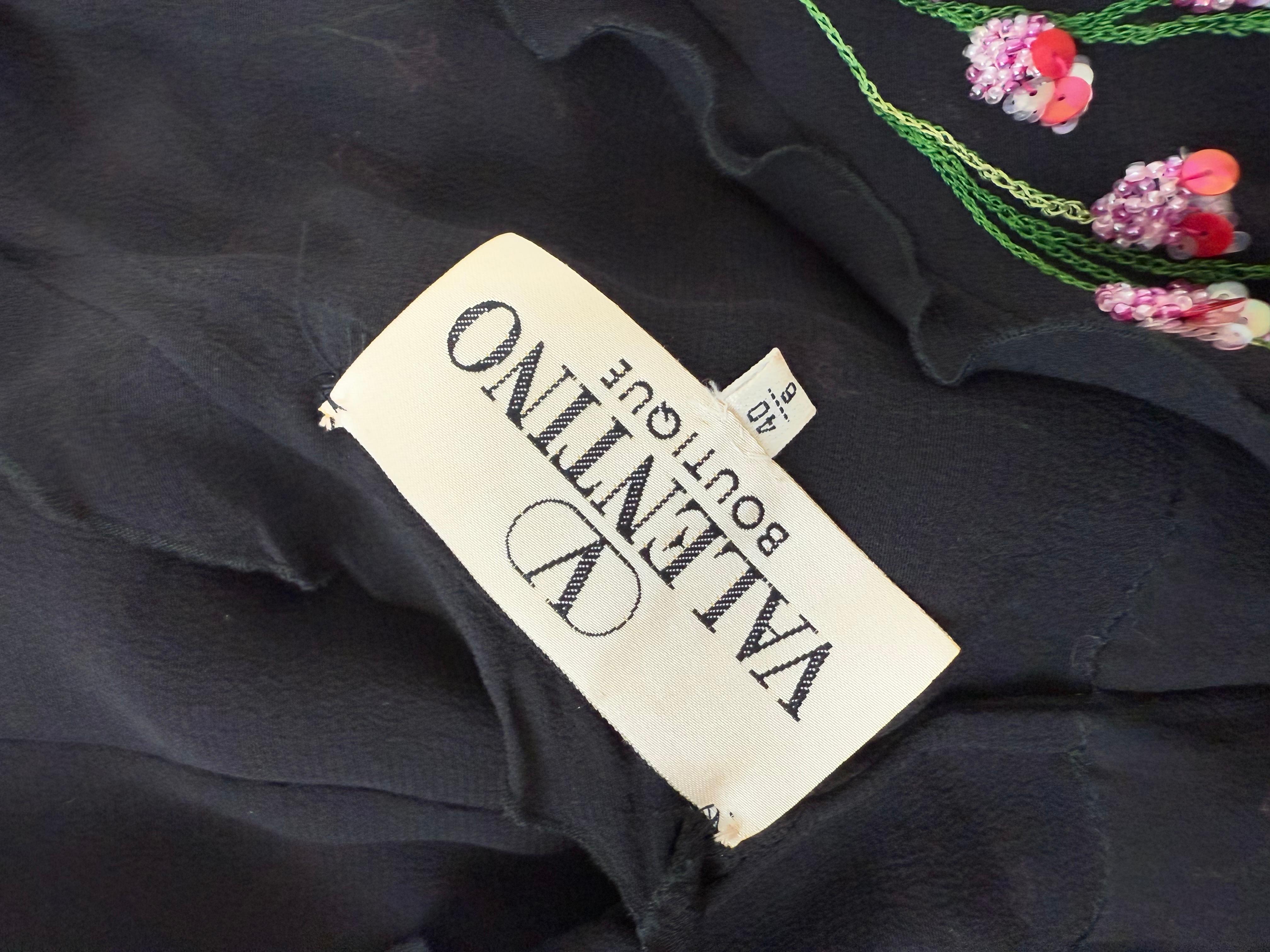 Valentino Boutique
Vintage
100% silk
Jet black silk with beautiful beads, sequins, and threading to create a romantic floral cascading pattern
Double v-neck front and back with delicate ruffles
Has a little pucker detail at the back
Invisible side