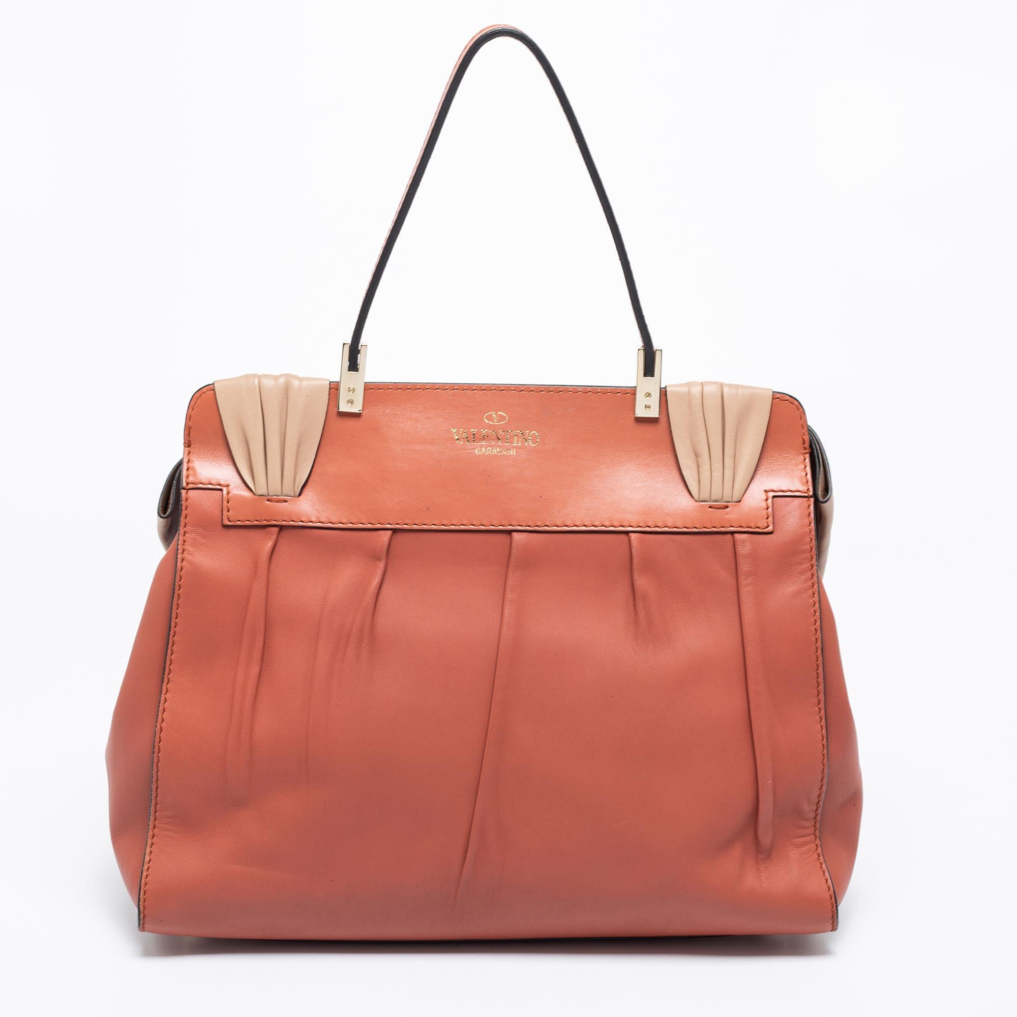 This feminine Aphrodite bag by Valentino will surely meet all your expectations. Crafted beautifully, it comes in lovely shades of brown & beige and is accented with an exaggerated bow at the front. Crafted from leather into an elegant design, it is