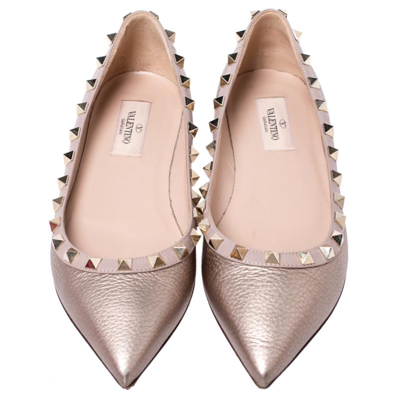 This pair of ballet flats from Valentino is perfect for lounging around. Crafted from bronze leather, they feature the signature Rockstuds along the trims and pointed toes. These comfortable flats come with leather-lined insoles.

Includes: Original