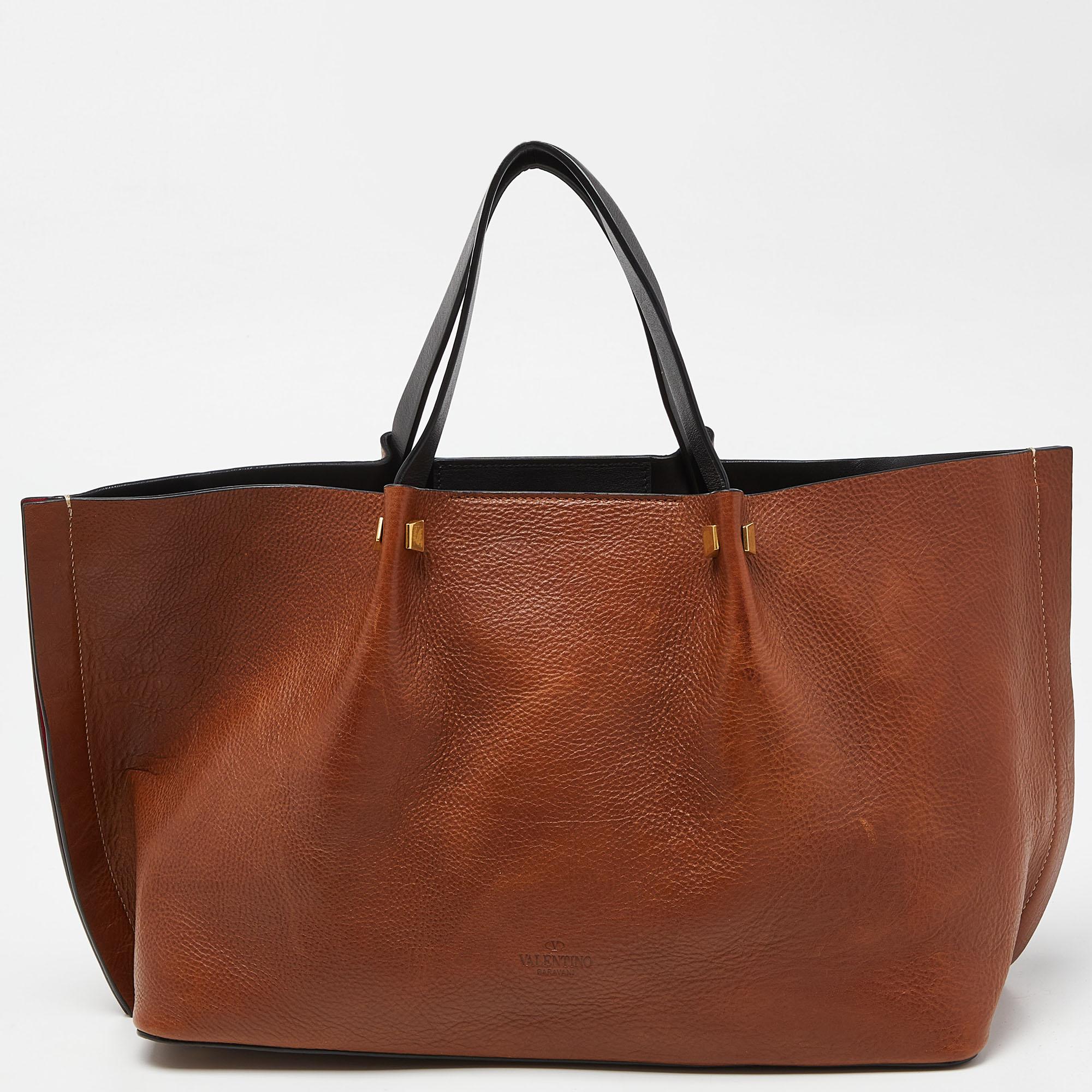 This Escape tote from Valentino represents a dialogue between innovation and tradition and will be your everyday companion. Made from fine leather, it features two top handles, an optional shoulder strap, and a spacious interior to store your