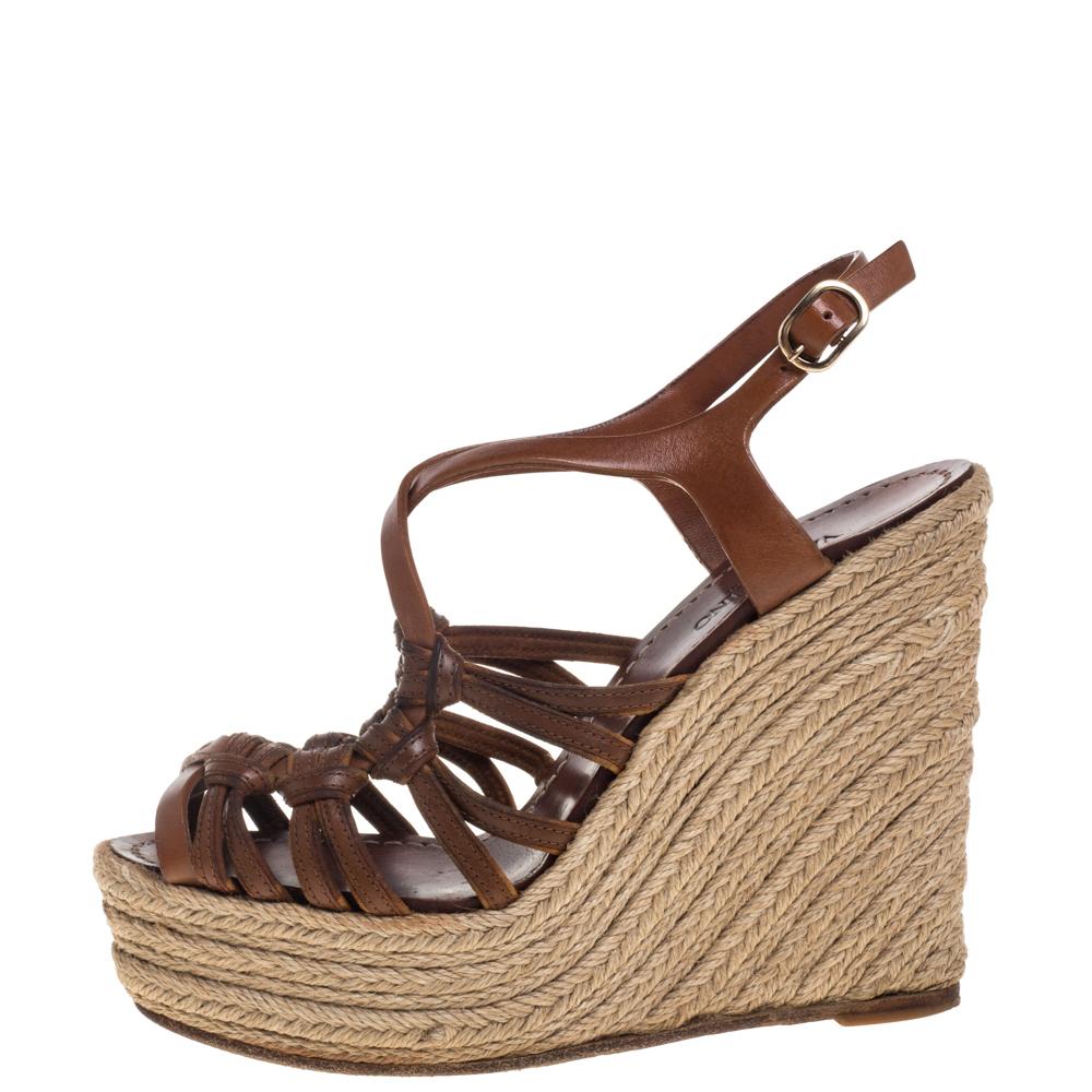 These Valentino sandals are perfect for casual outings as they simultaneously ensure comfort and style. Crafted from brown leather, they feature entwined vamp straps and ankle straps with gold-tone buckle fastenings. They have leather-lined insoles