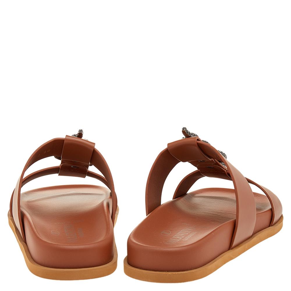 These slides from Valentino are easy to slip on. They have been crafted from leather and designed with an embellished snake motif on the uppers. They come in a shade of brown to essay style in an effortless way.

Includes: Original Packaging